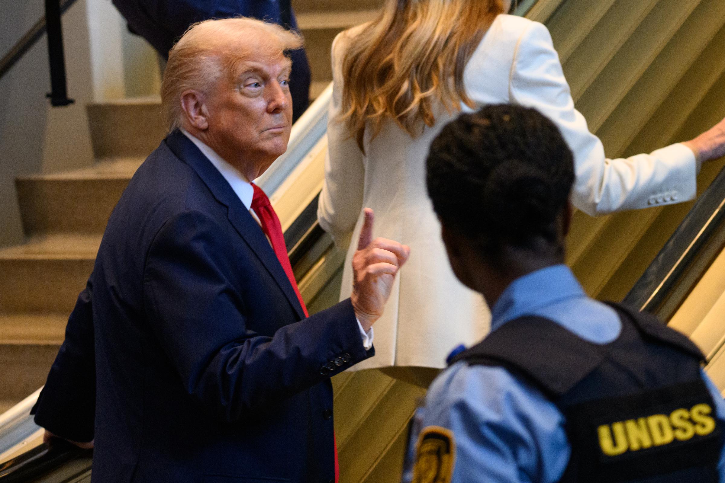 Donald Trump raising his index finger while at the bottom of the escalator. | Source: Getty Images
