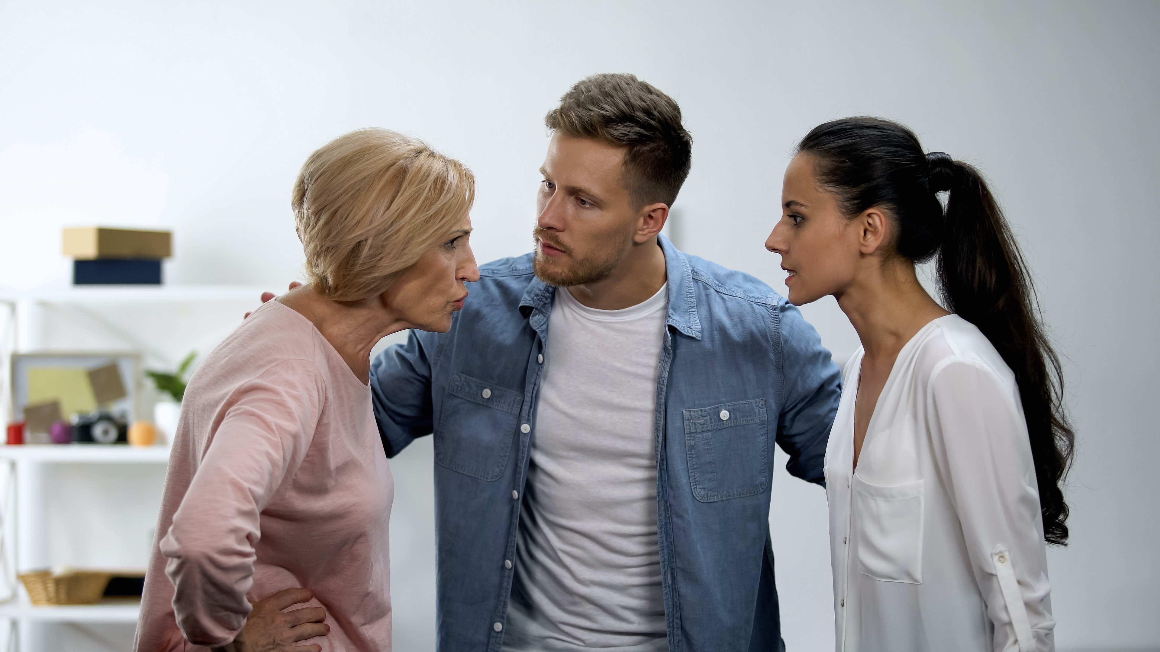 A man mediating an argument between an older woman and a younger woman | Source: Shutterstock