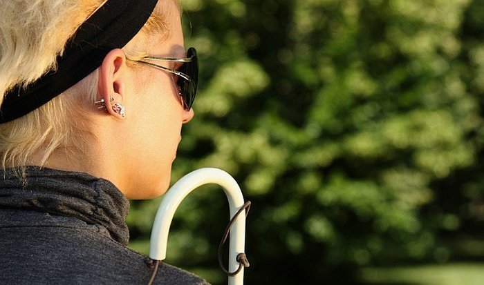 Mujer con gafas oscuras y bastón. | Foto: Shutterstock