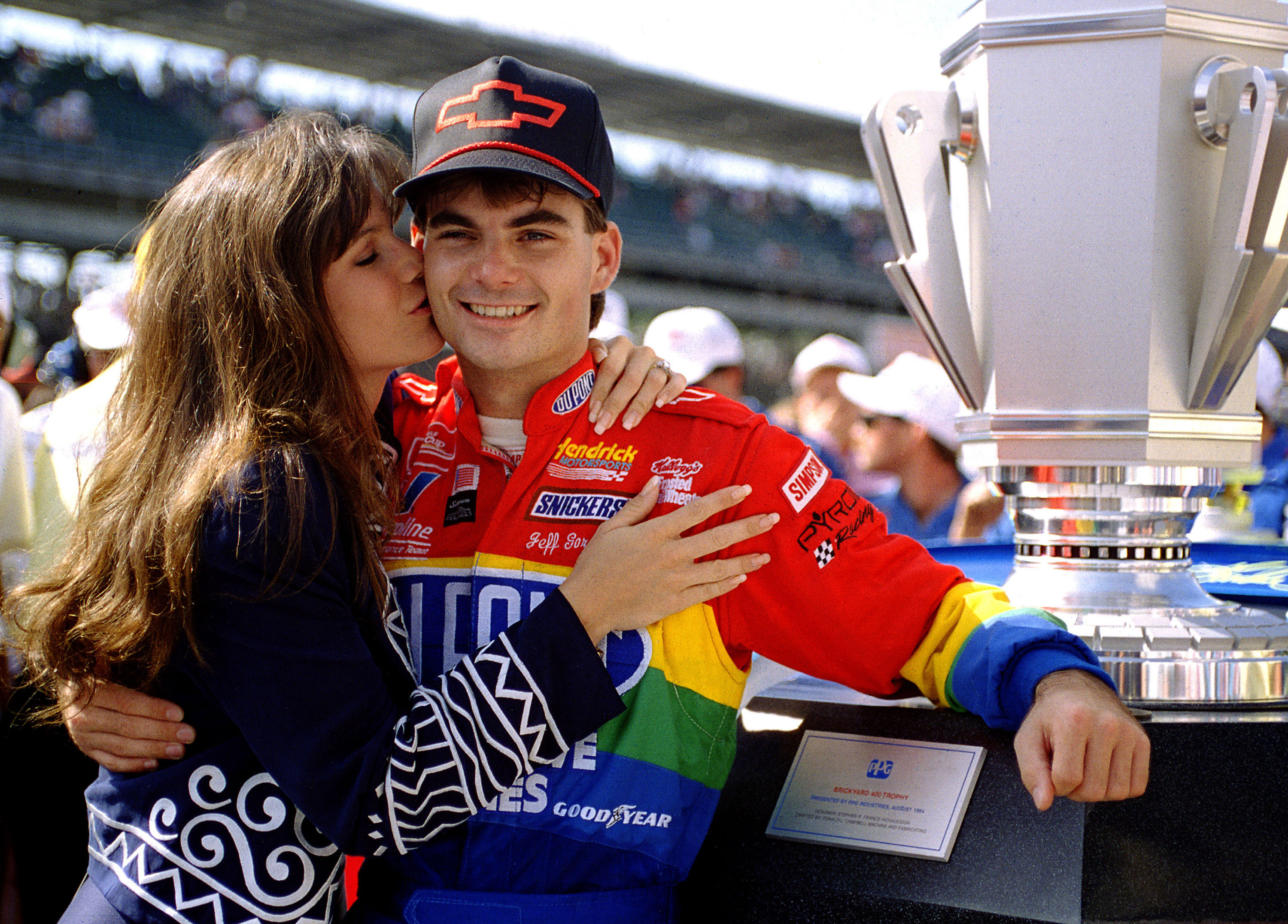 Brooke Sealey giving  Jeff Gordon a congratulatory kiss after winning the inaugural Brickyard 400 NASCAR race on August 6, 1994, in Indianapolis, Indiana. | Source: Getty Images