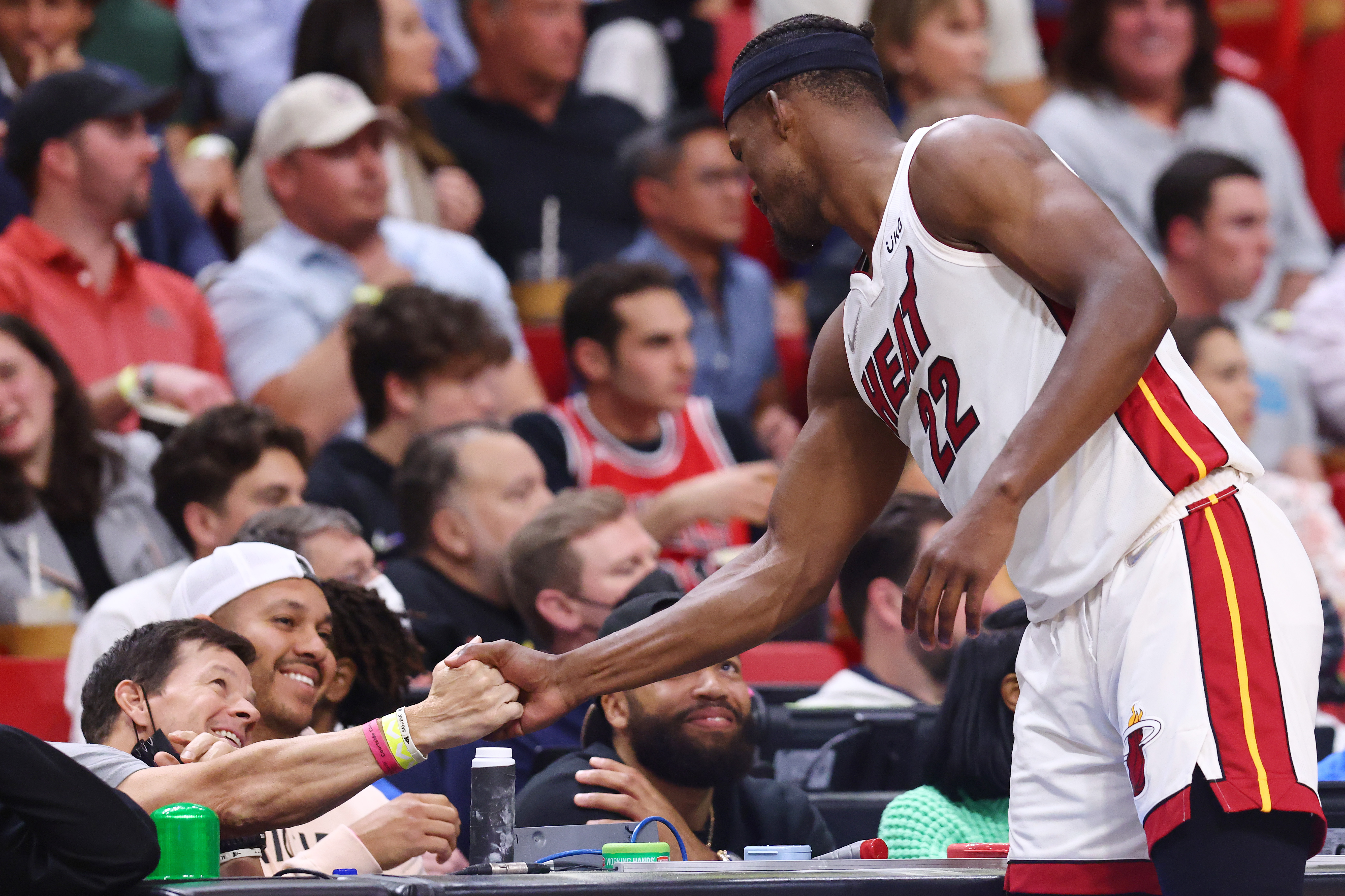Jimmy Butler greets Mark Wahlberg during the first half against the Chicago Bulls at FTX Arena on February 28, 2022, in Miami, Florida. | Source: Getty Images