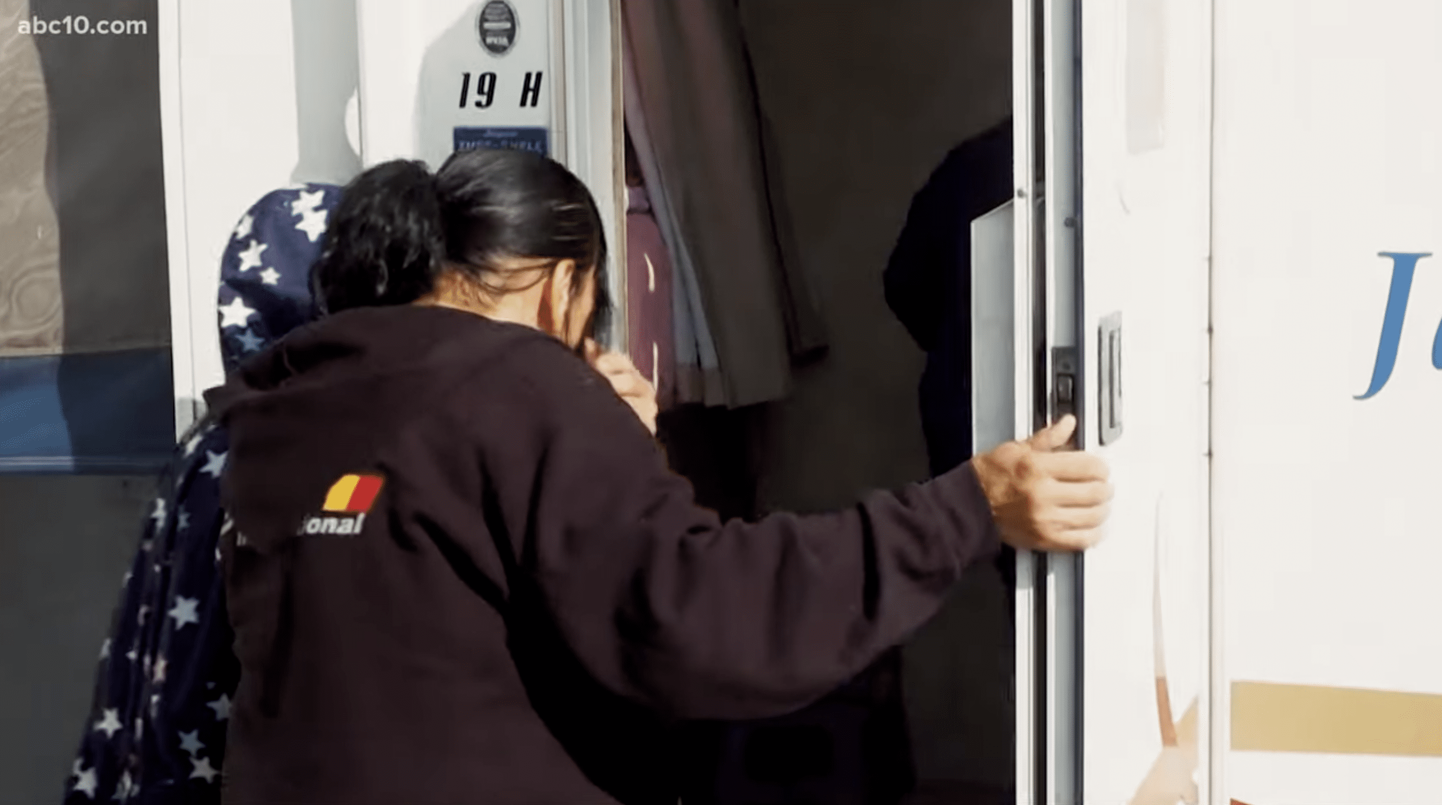 Felicia Washington entering inside the new trailer with her kids. | Photo: YouTube.com/ABC10