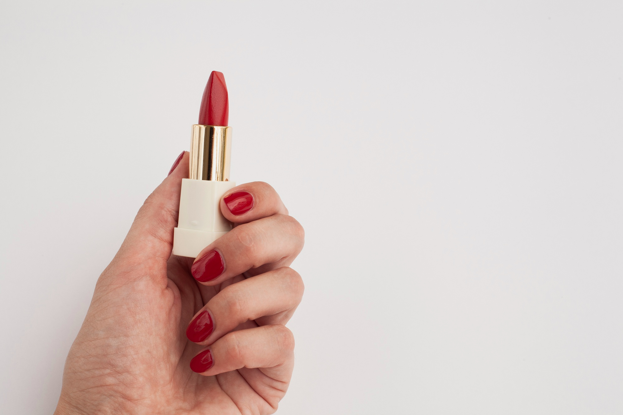 A woman holding a lipstick | Source: freepik.com