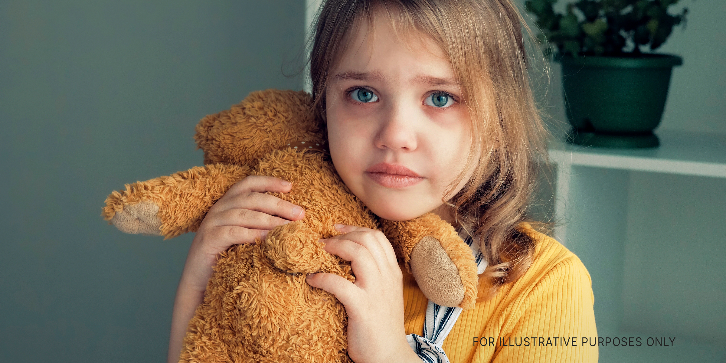 A small girl holding a teddy bear | Source: Shutterstock
