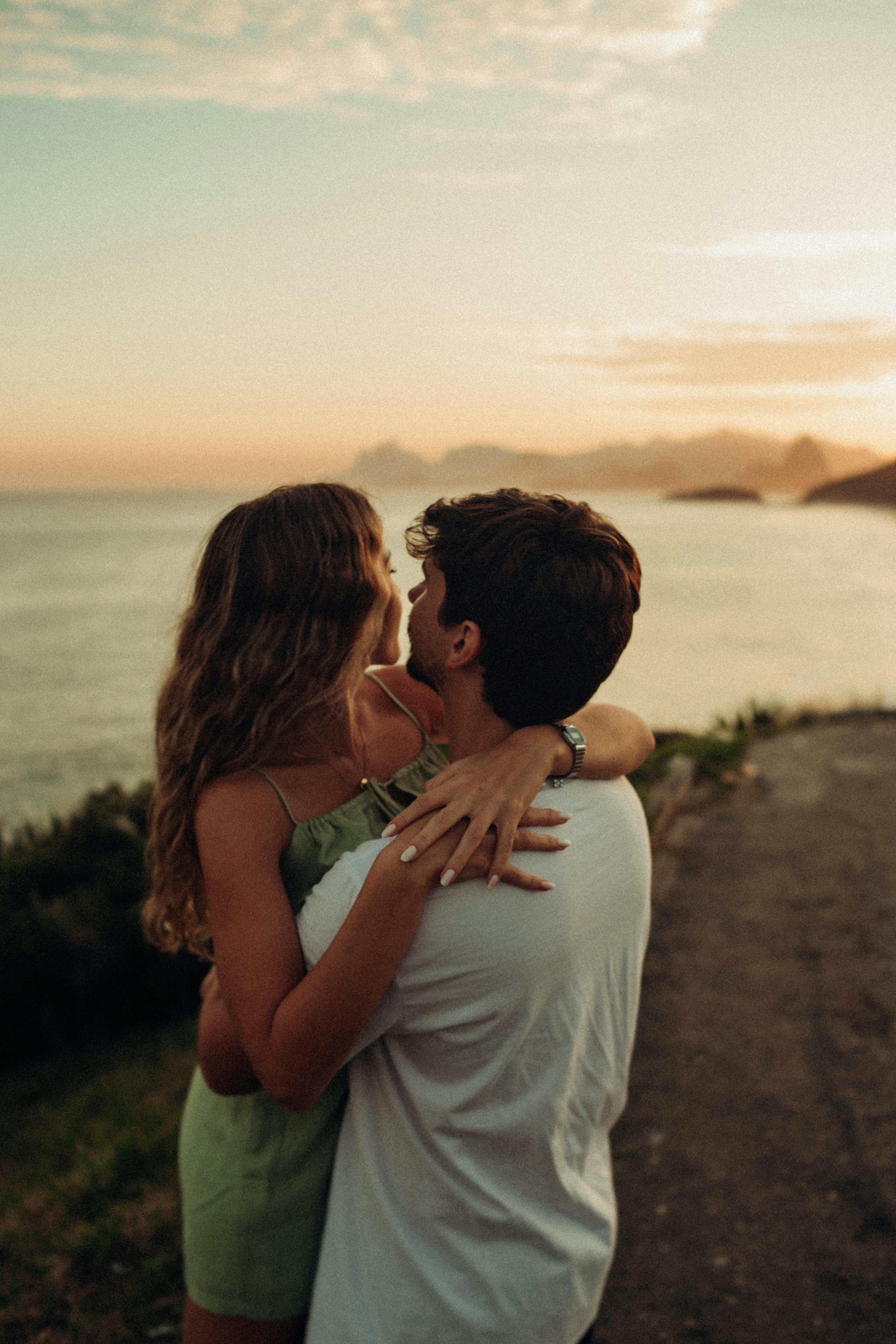 A couple embracing on the beach at sunset | Source: Pexels
