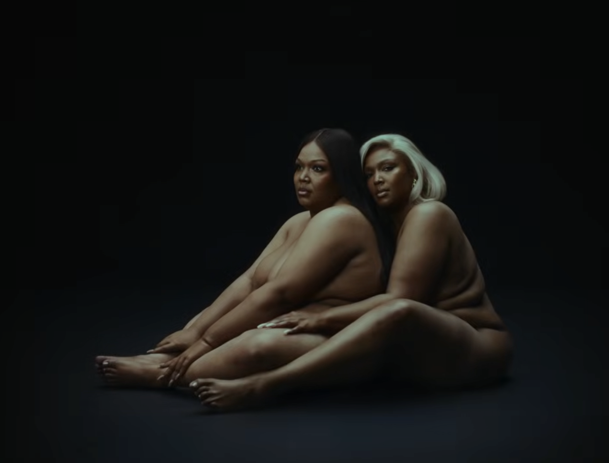 Two versions sit closely side by side in a stripped-down studio frame | Source: YouTube/Lizzo