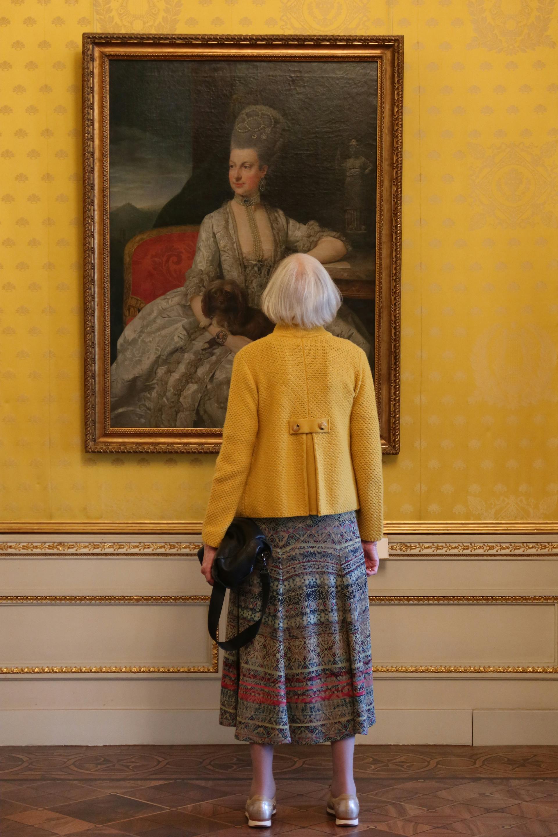 An elderly woman looking at a painting | Source: Pexels