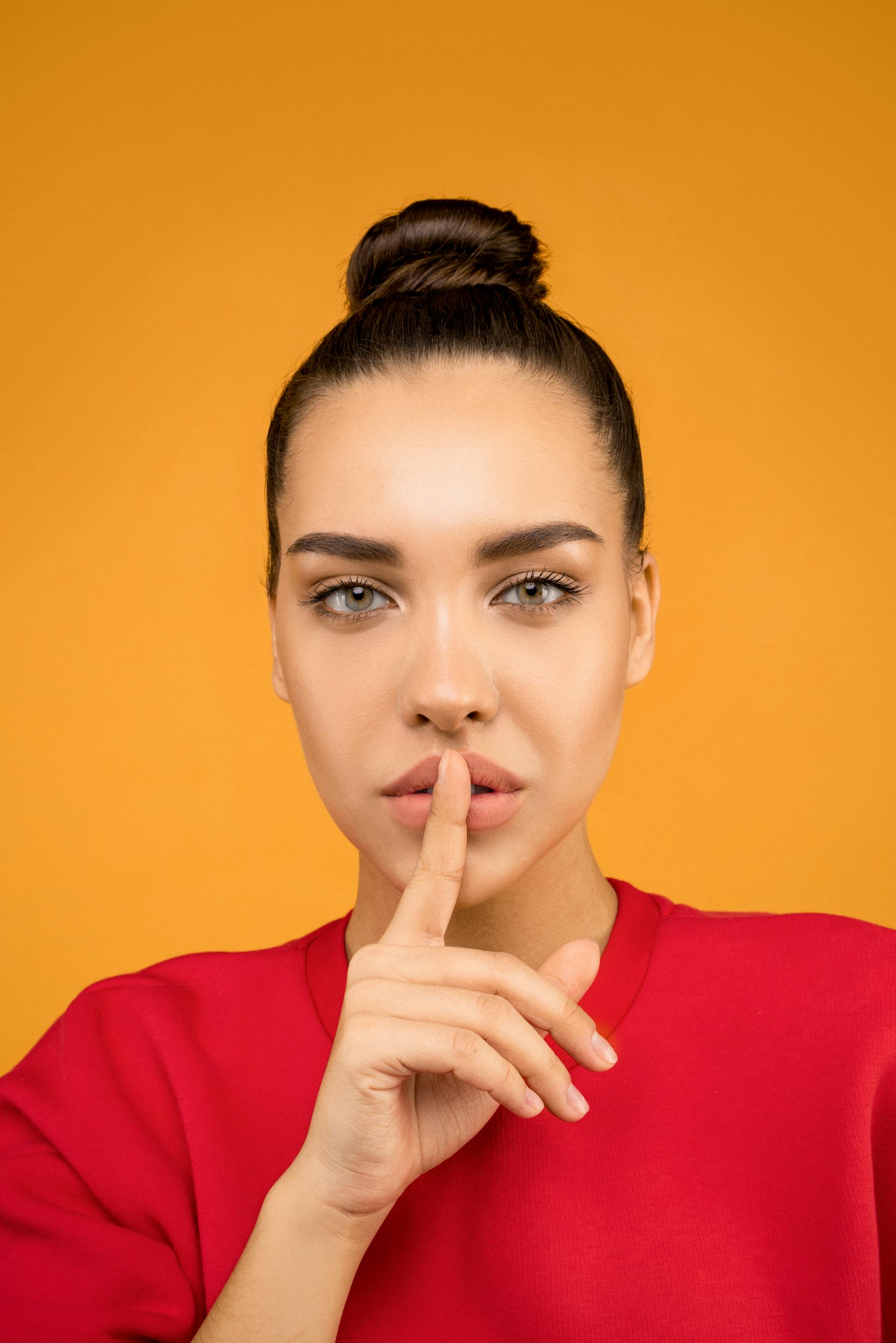 A woman putting a finger to her lips | Source: Pexels