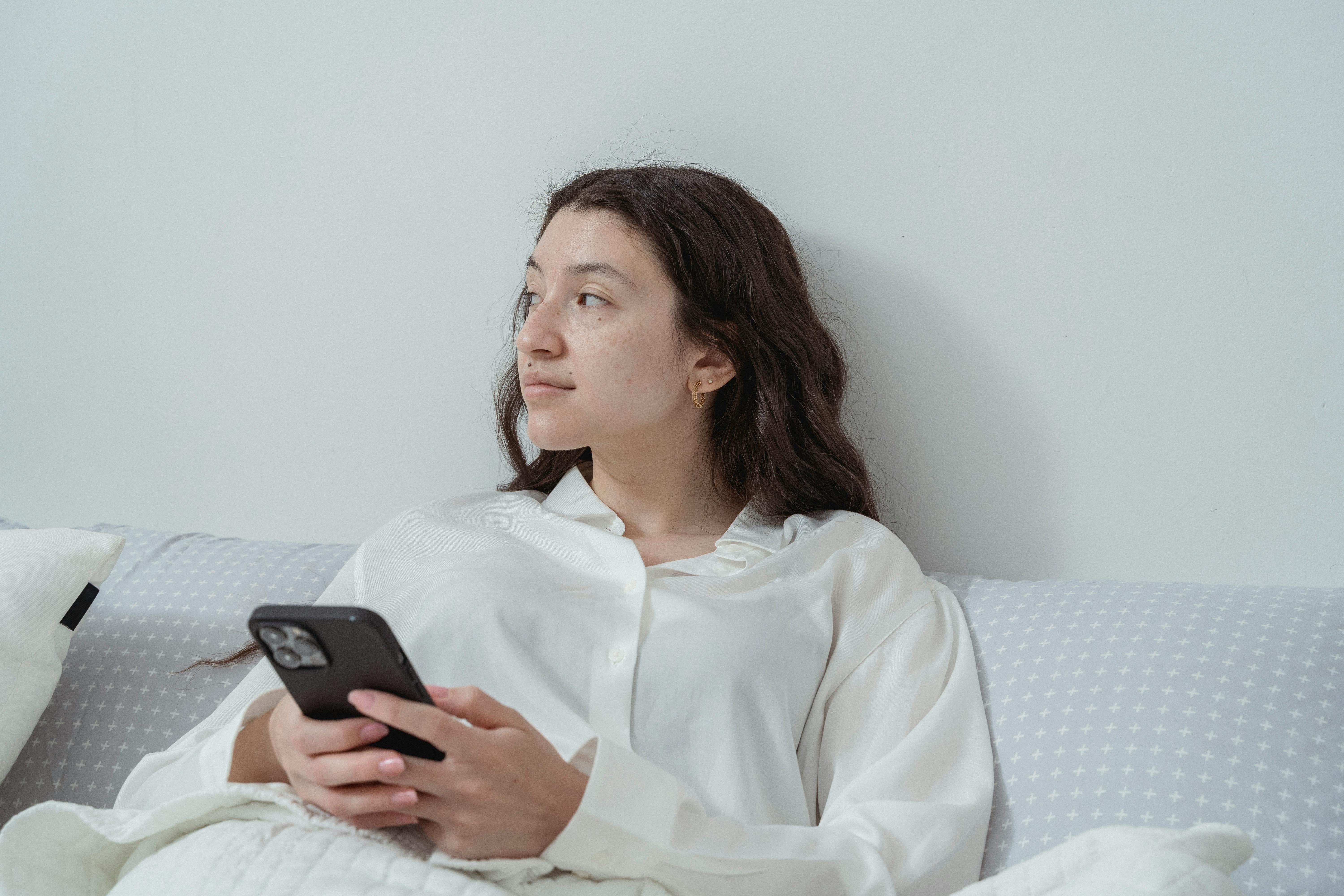 A woman smiling while sitting in bed | Source: Pexels