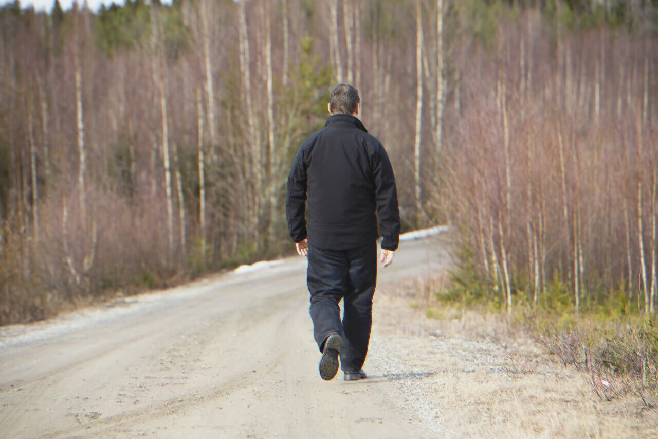 Lonely man walking on a road | Source: Shutterstock