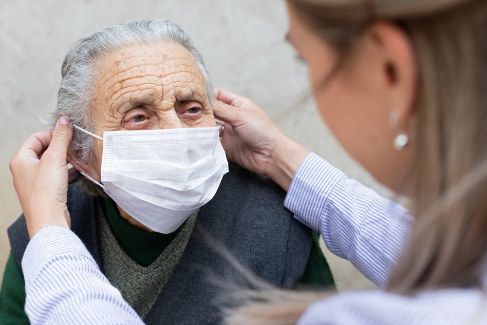 Enfermera coloca mascarilla a un anciano. | Foto: Shutterstock