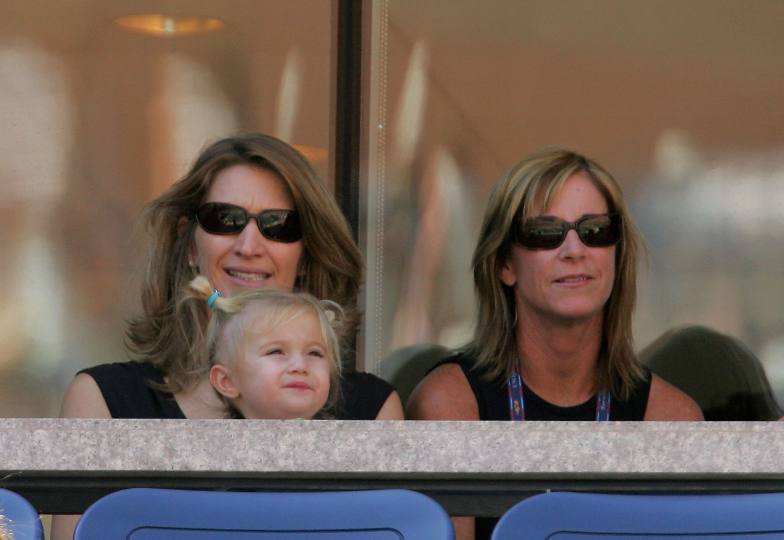 Steffi Graf, her daughter, Jaz Elle, on her lap, and a friend watch Andre Agassi play against Robby Ginepri at the semifinals of the US Open on September 10, 2005, in the Flushing neighborhood of the Queens borough of New York. | Source: Getty Images
