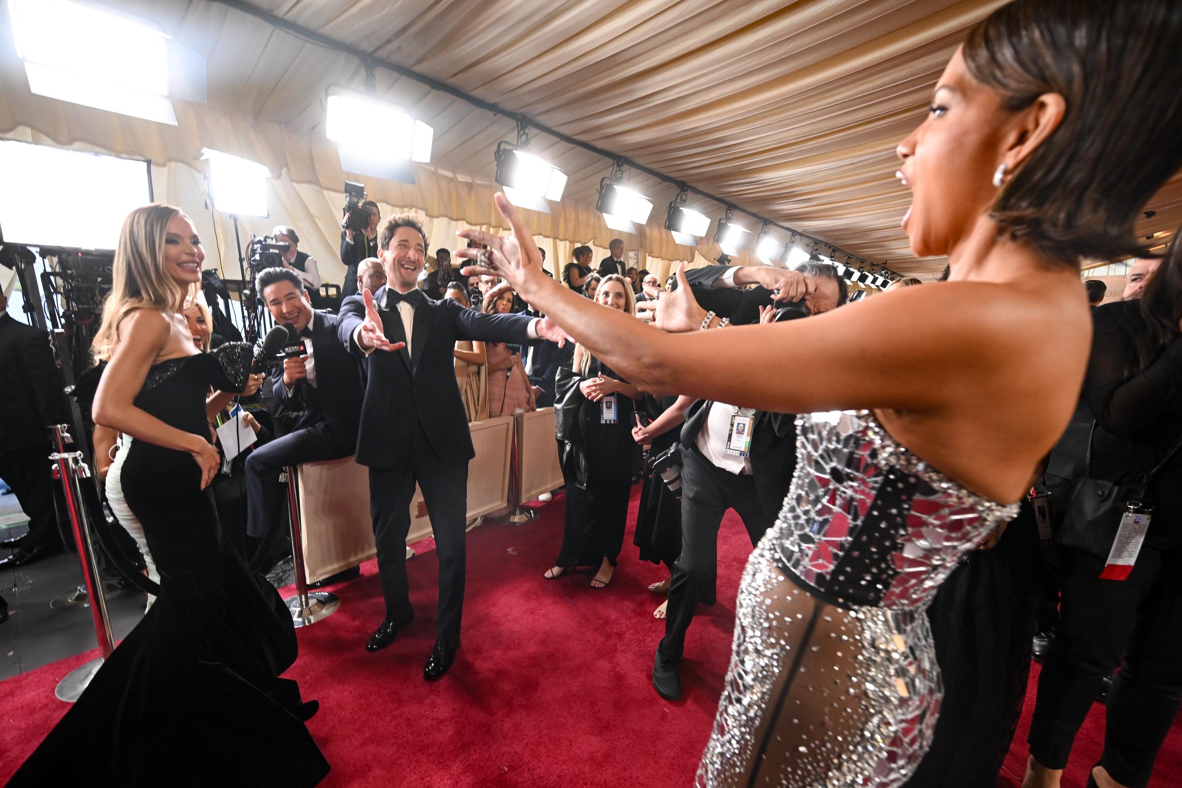 Adrien Brody sharing a moment on the red carpet with Halle Berry as Georgina Chapman looks on. | Source: Getty Images