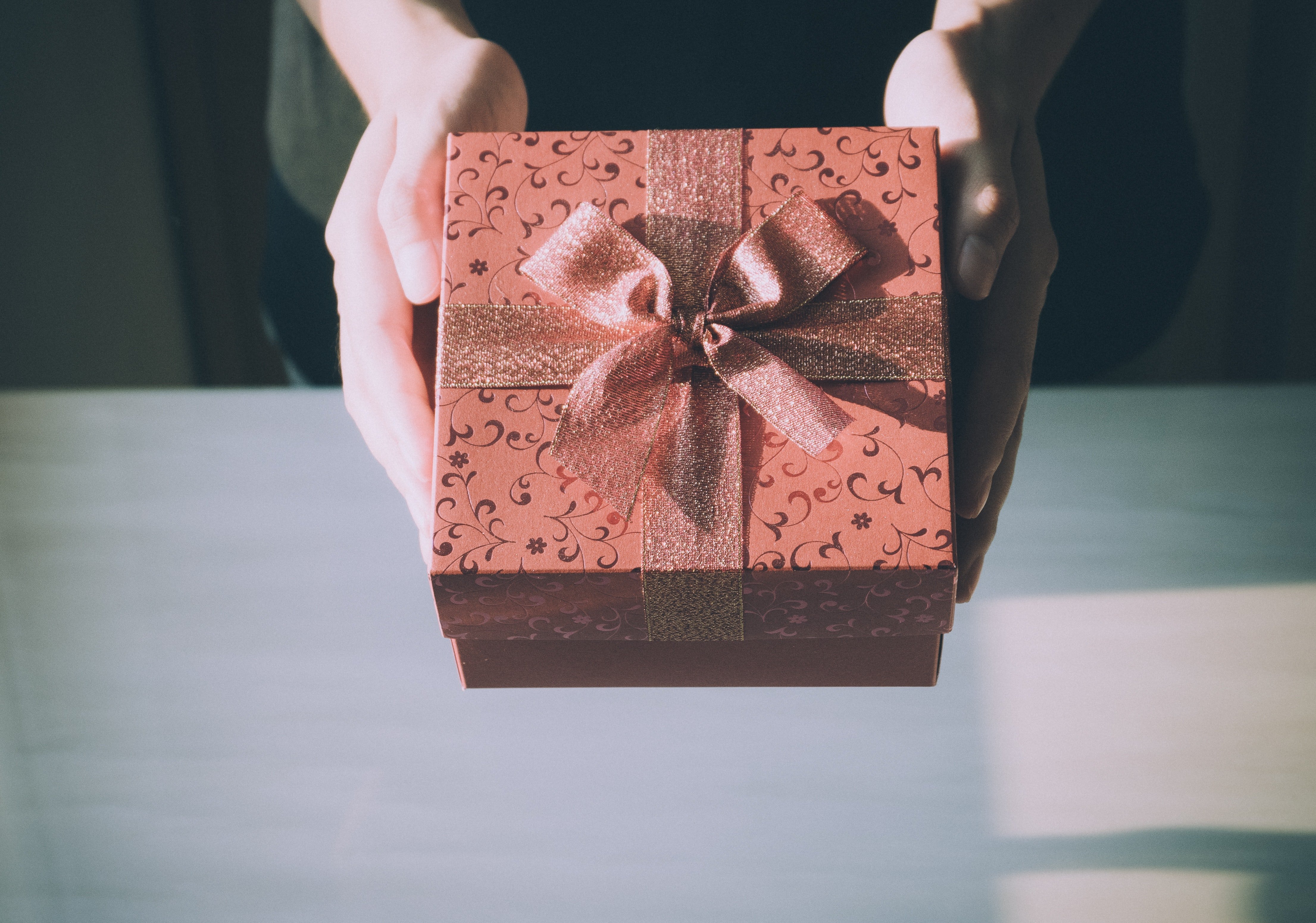 Manos sostienen una pequeña caja de regalo. | Foto: Pexels
