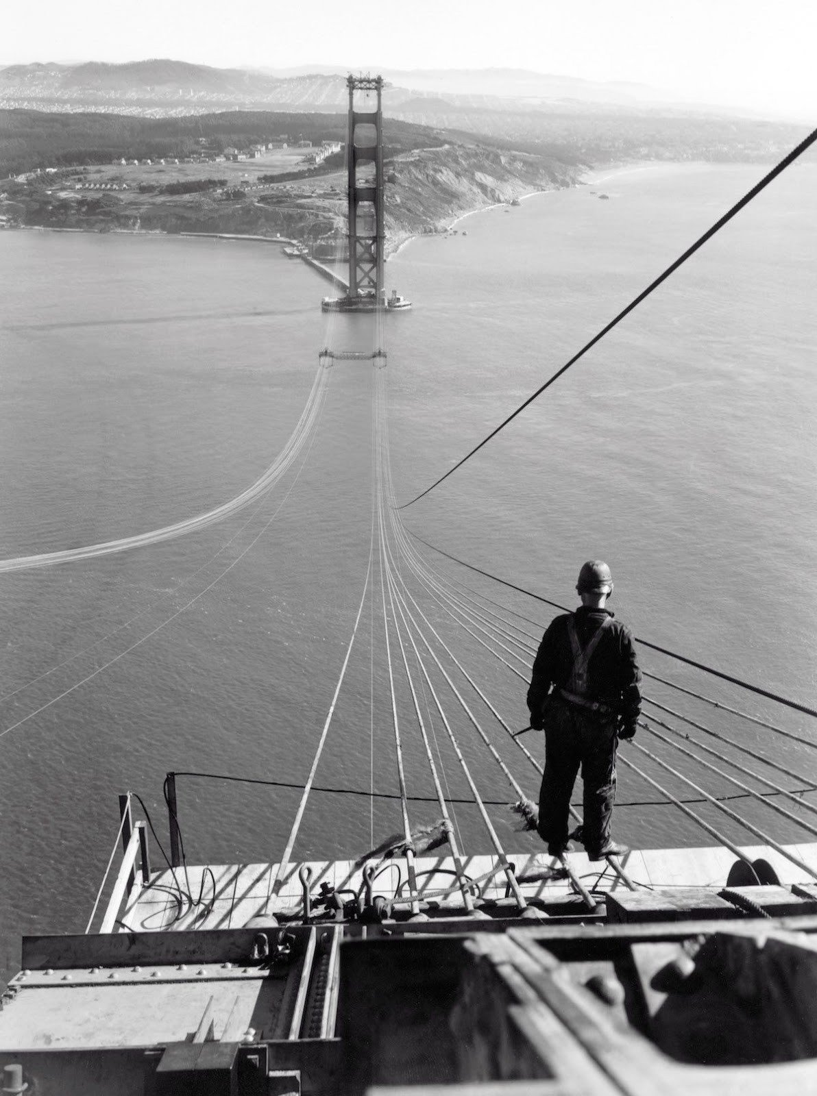 A man stands on the first cables of the Golden Gate Bridge during its construction,1935. Image Source: YouTube/Medium