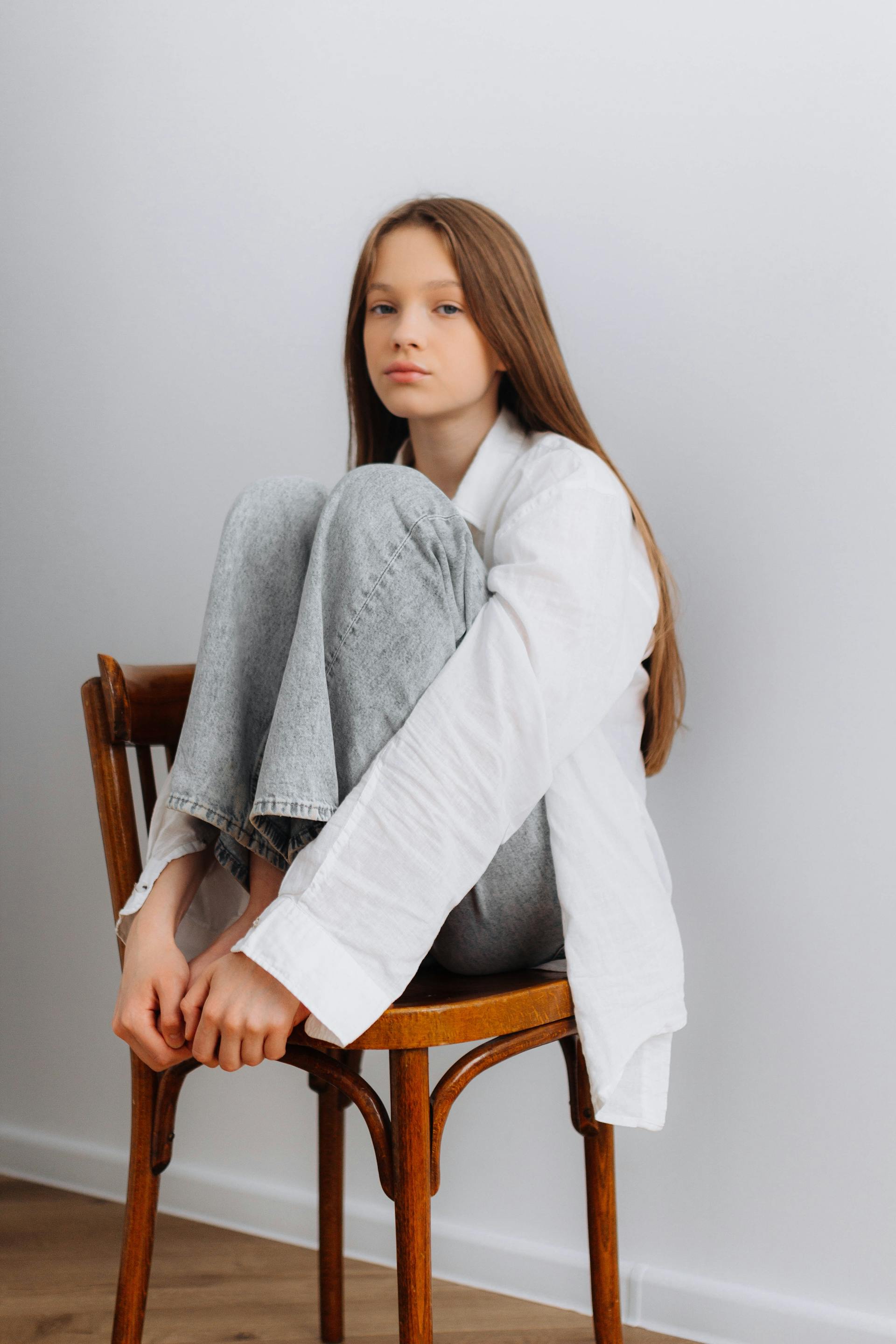 A teenage girl sitting on a chair | Source: Pexels