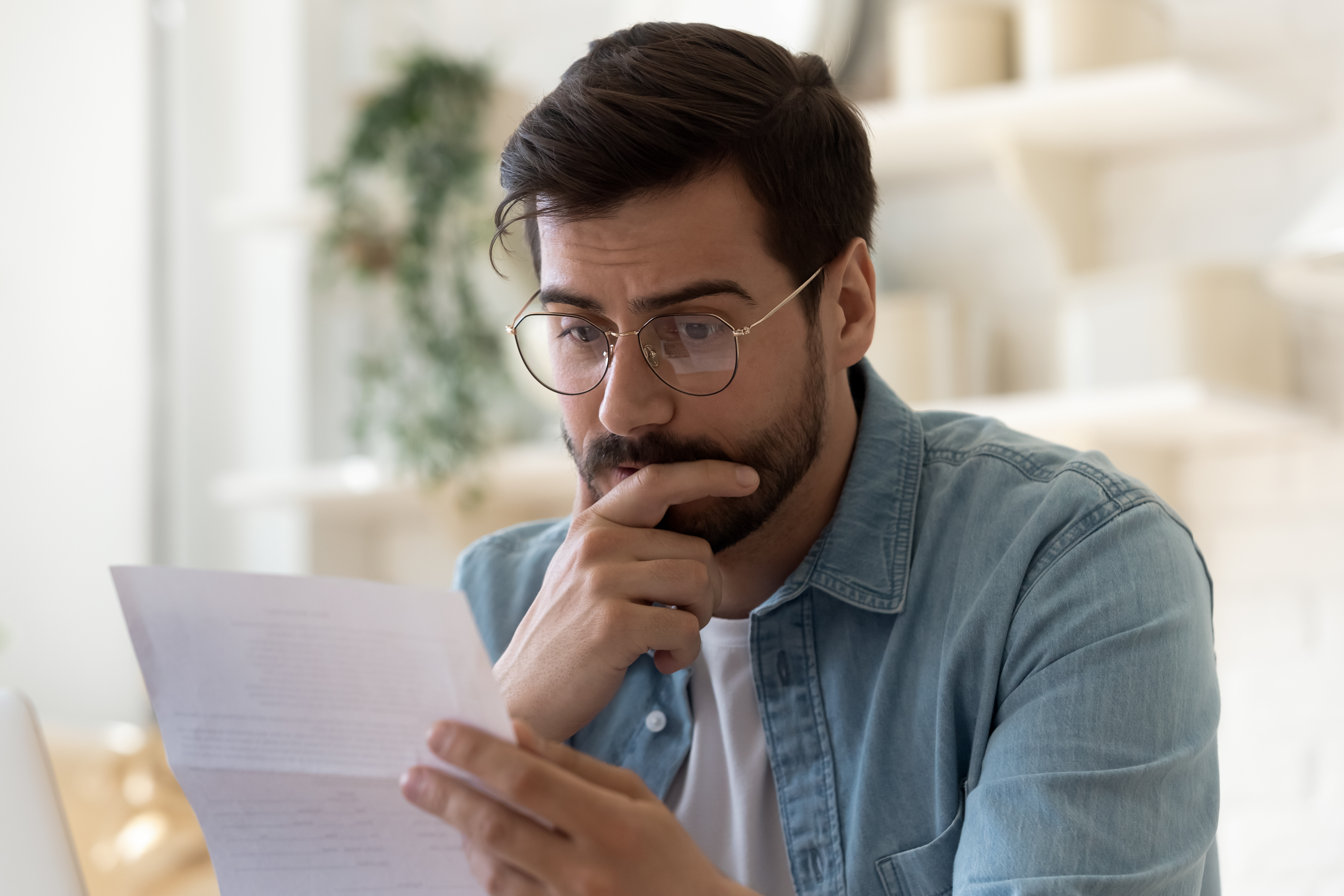Confused man with documents | Source: Shutterstock.com