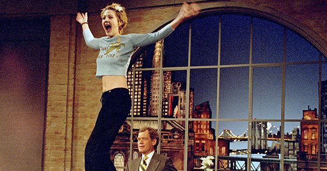 Drew Barrymore turns to the audience after flashing host David Letterman during a taping of the Late Show with David Letterman , April 1995 | Source: Getty Images