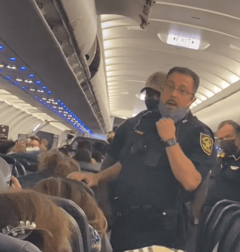 A cop addressing an airplane passenger. | Source: tiktok.com/heyalexa_nah