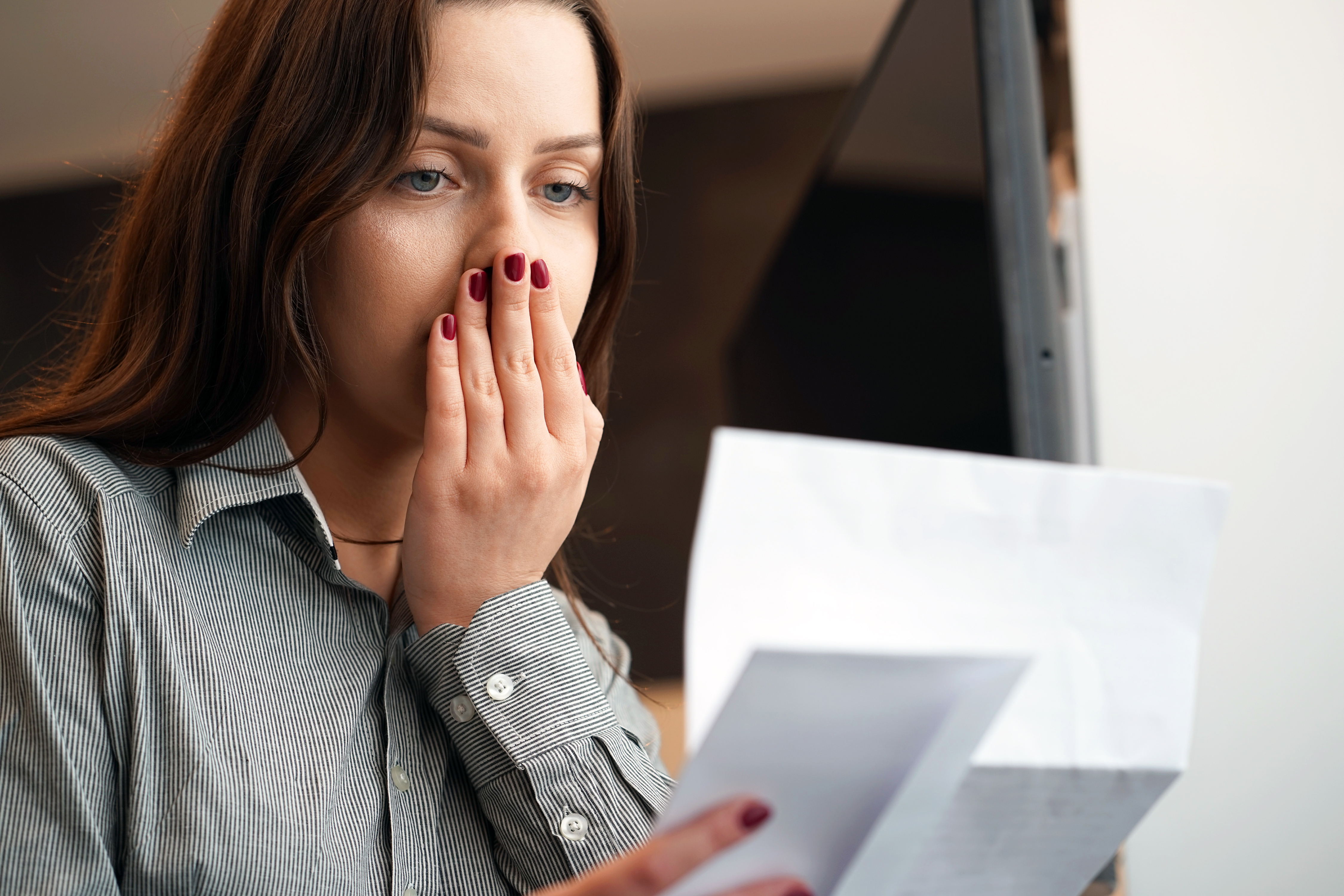 A shocked woman looking at paperwork | Source: Getty Images