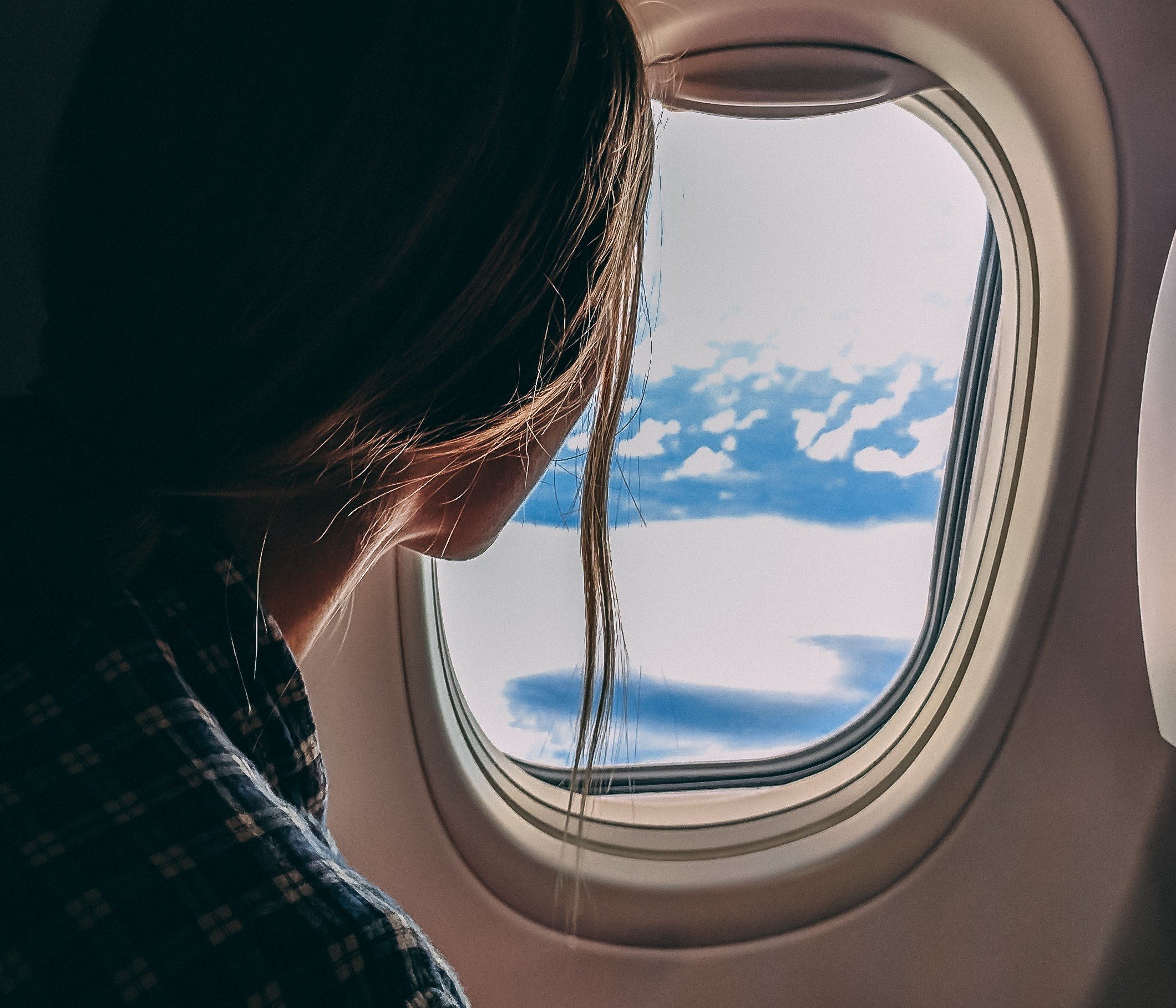 Mujer viendo por la ventanilla de un avión. 