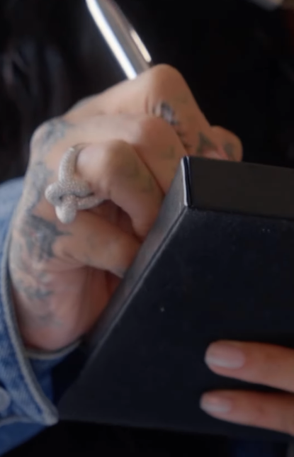 Rihanna writing something in her new video dated February 23, 2026 | Source: Instagram/badgalriri