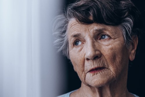 Alte Frau schaut aus dem Fenster | Quelle: Shutterstock