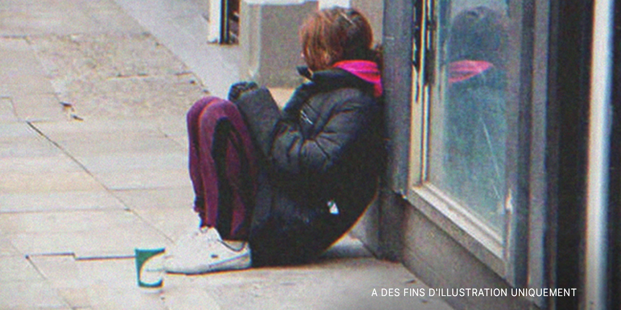 Une jeune fille assise dans la rue | Source : Shutterstock