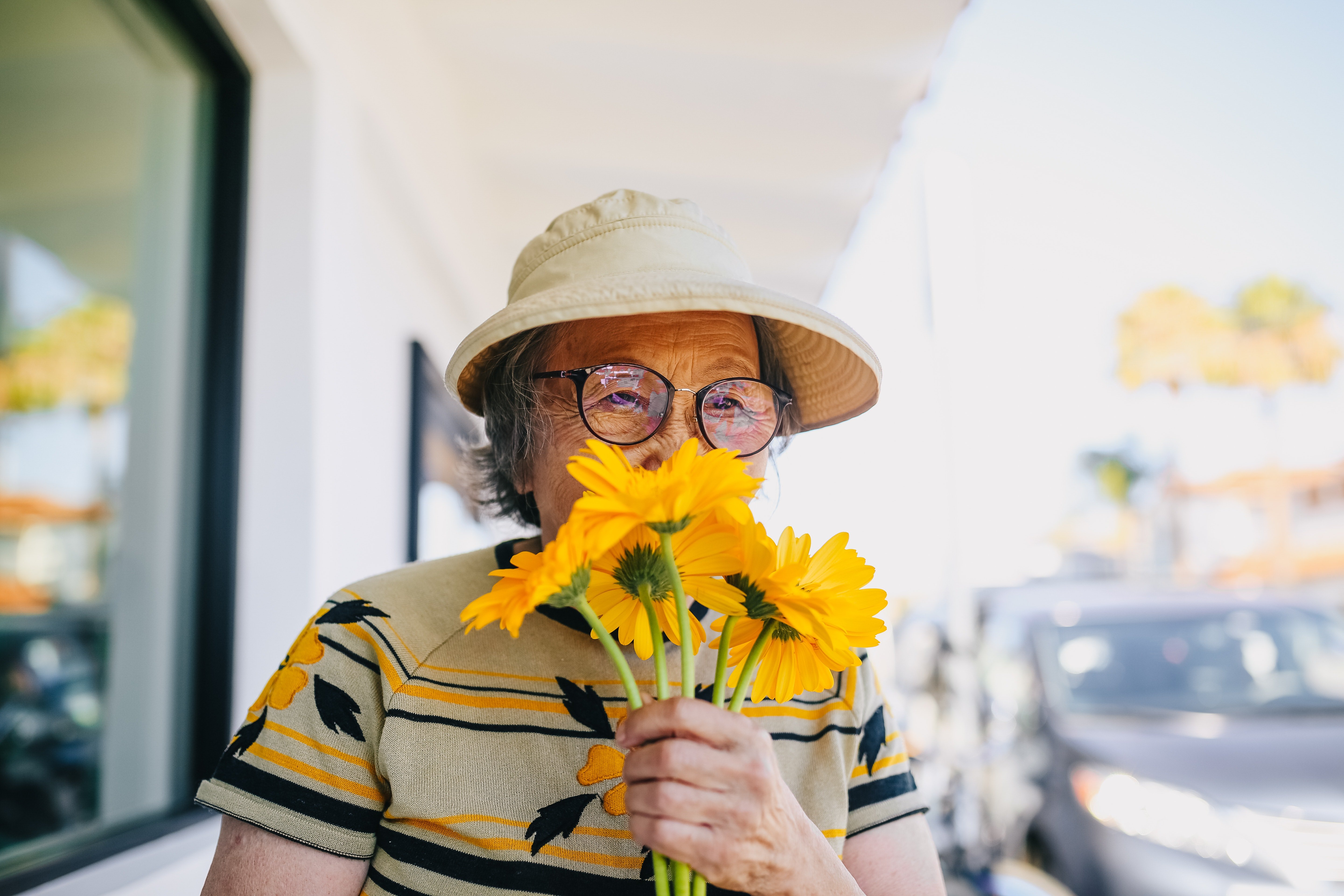 Une femme âgée tienne une fleure. | Photo : Pexels