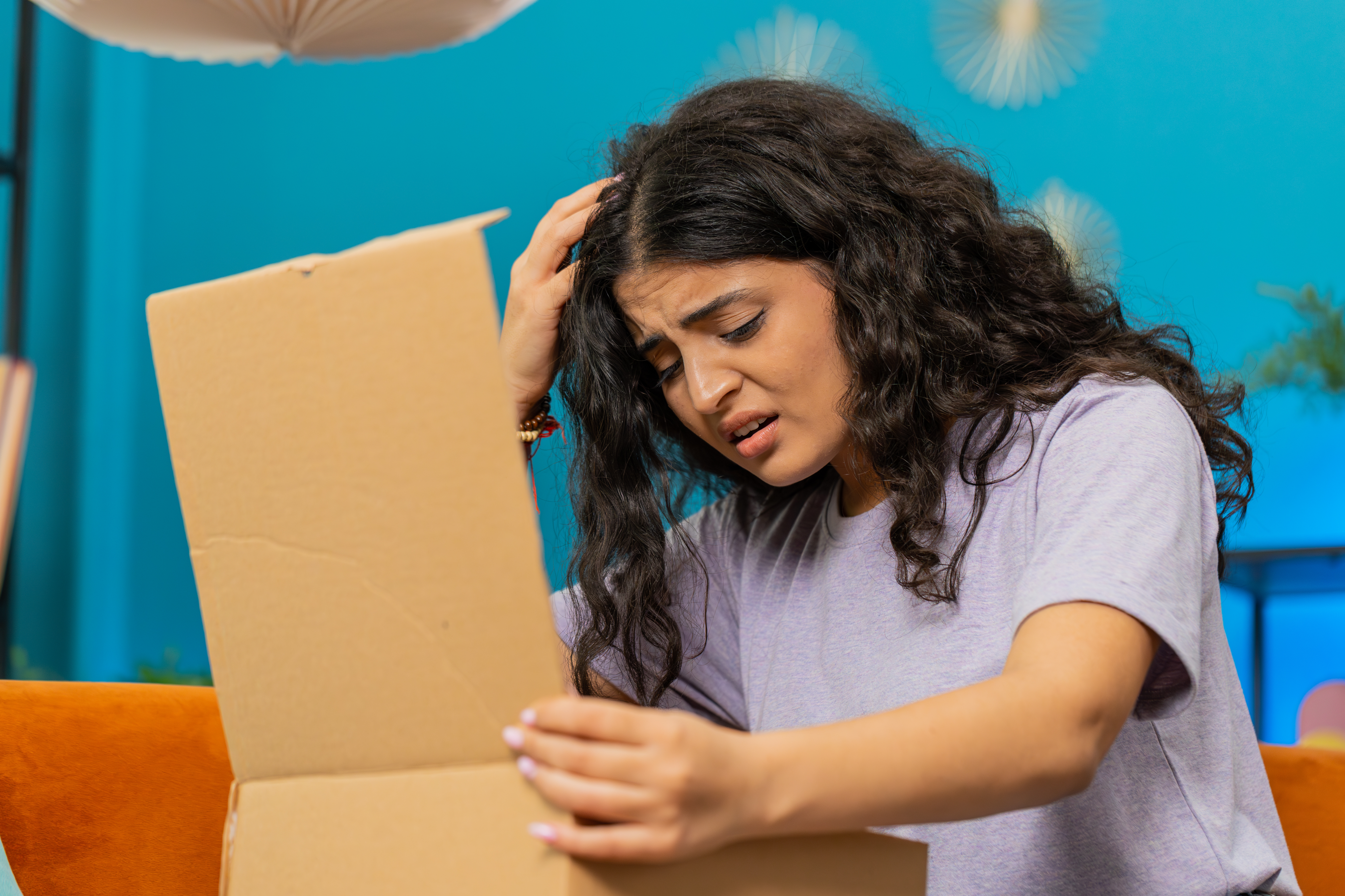 An upset woman looking at something in a box | Source: Getty Images