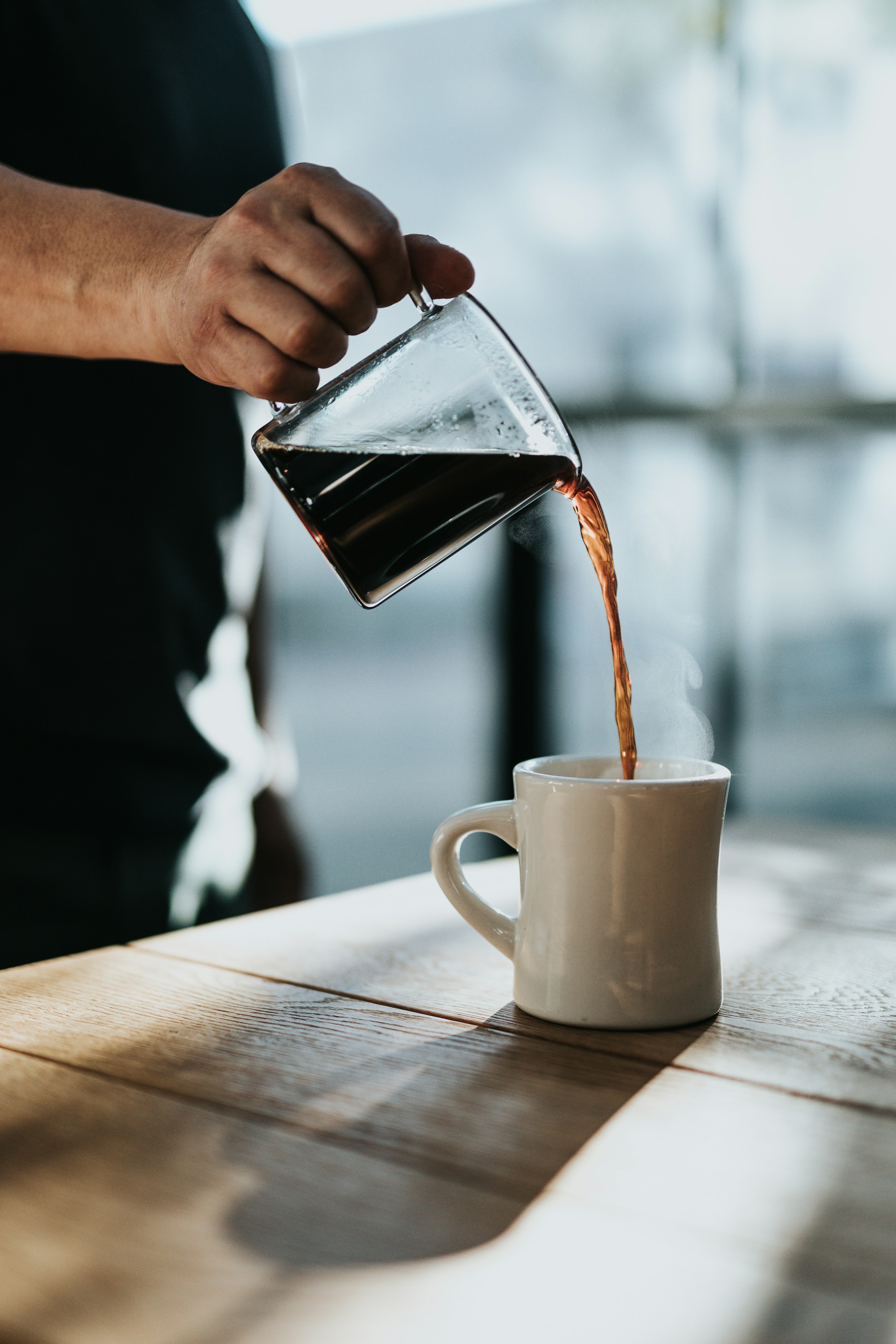 Person pouring coffee into a mug | Source: Unsplash