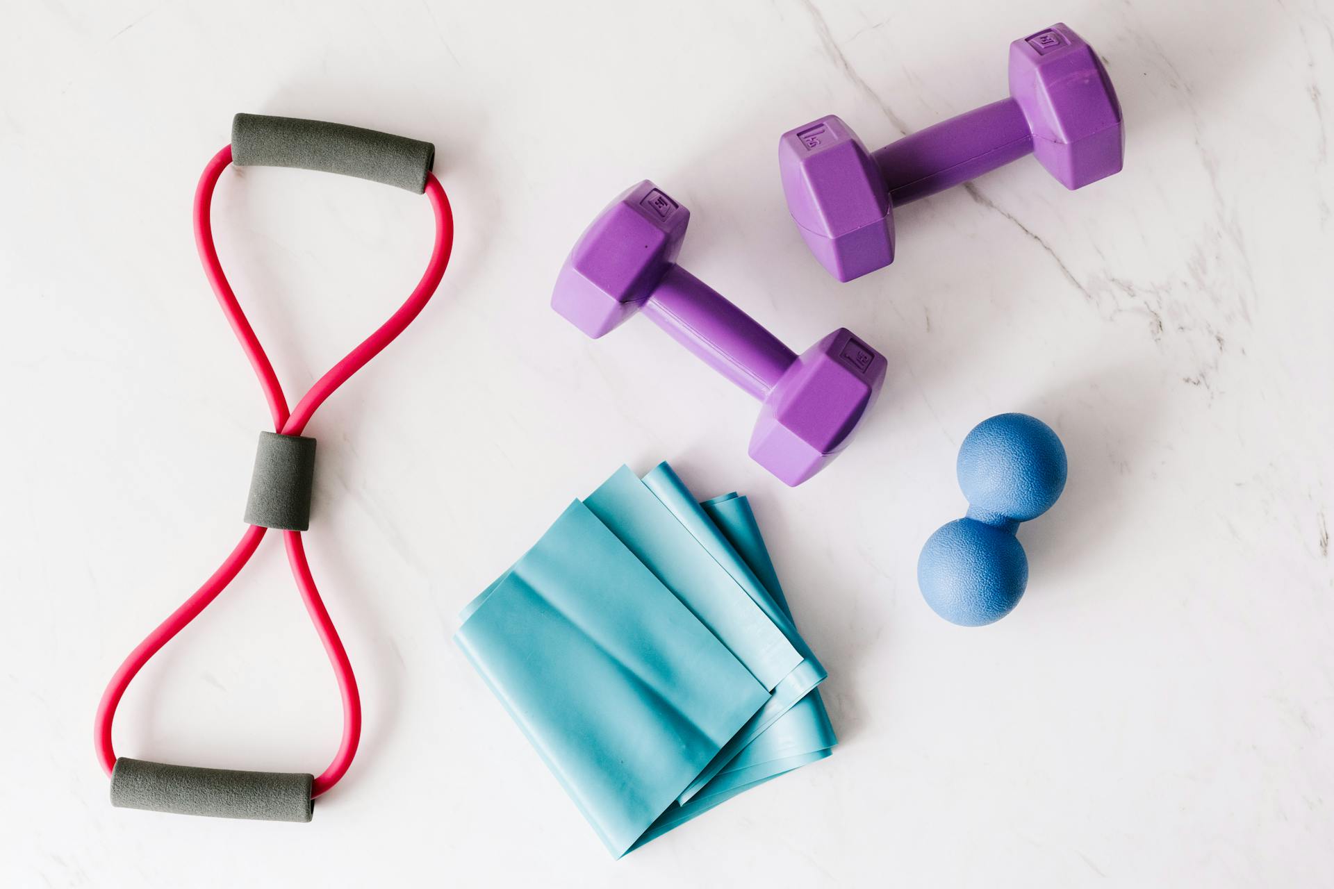 A set of fitness equipment placed on a marble surface | Source: Pexels