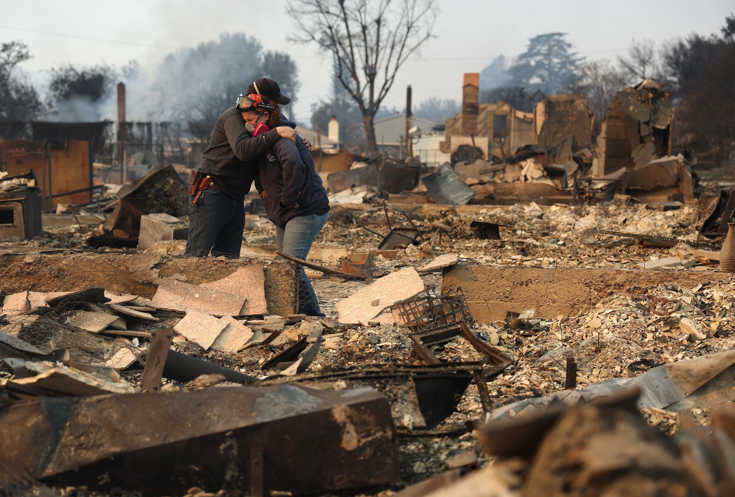 Khaled Fouad (L) and Mimi Laine (R) embrace as they inspect a family member's property that was destroyed by Eaton Fire on January 09, 2025, in Altadena, California | Source: Getty Images