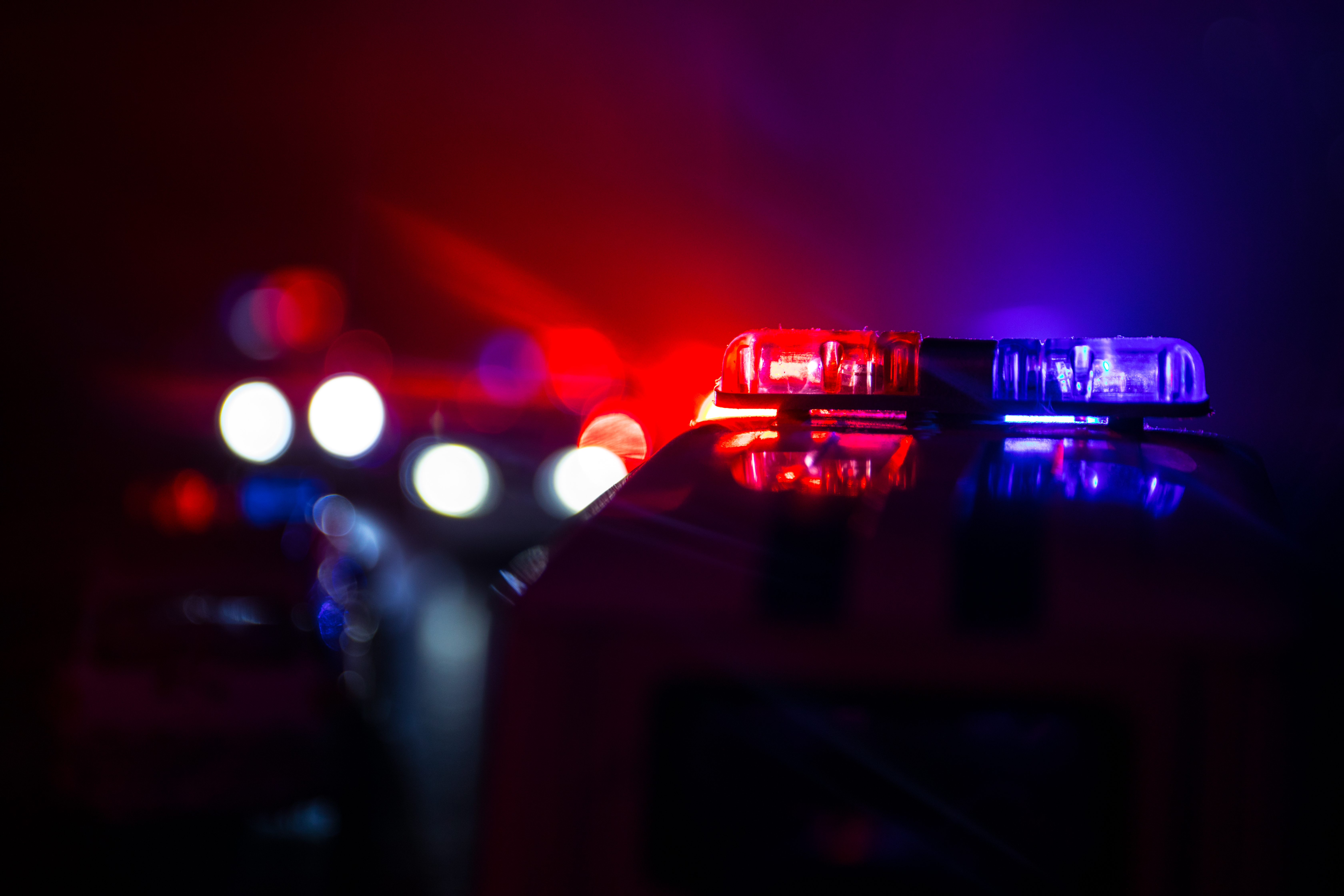 Police cars at night. Police car chasing a car at night with fog background. 911 Emergency response police car speeding to scene of crime. Selective focus | Source: Shutterstock