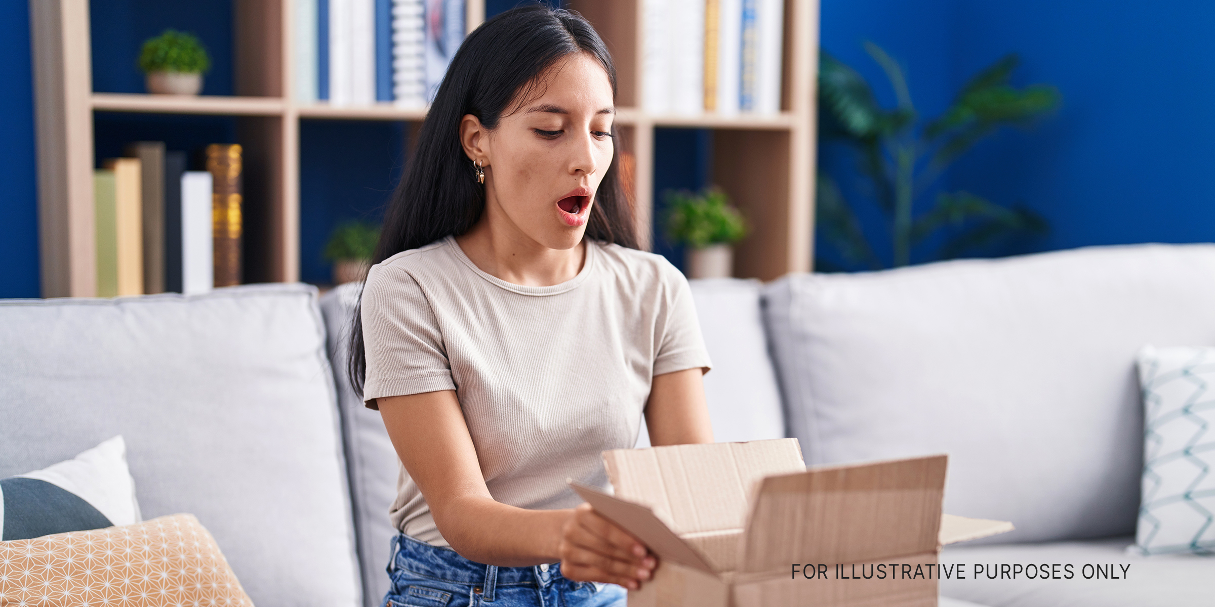 Shocked woman opening a box | Source: Shutterstock