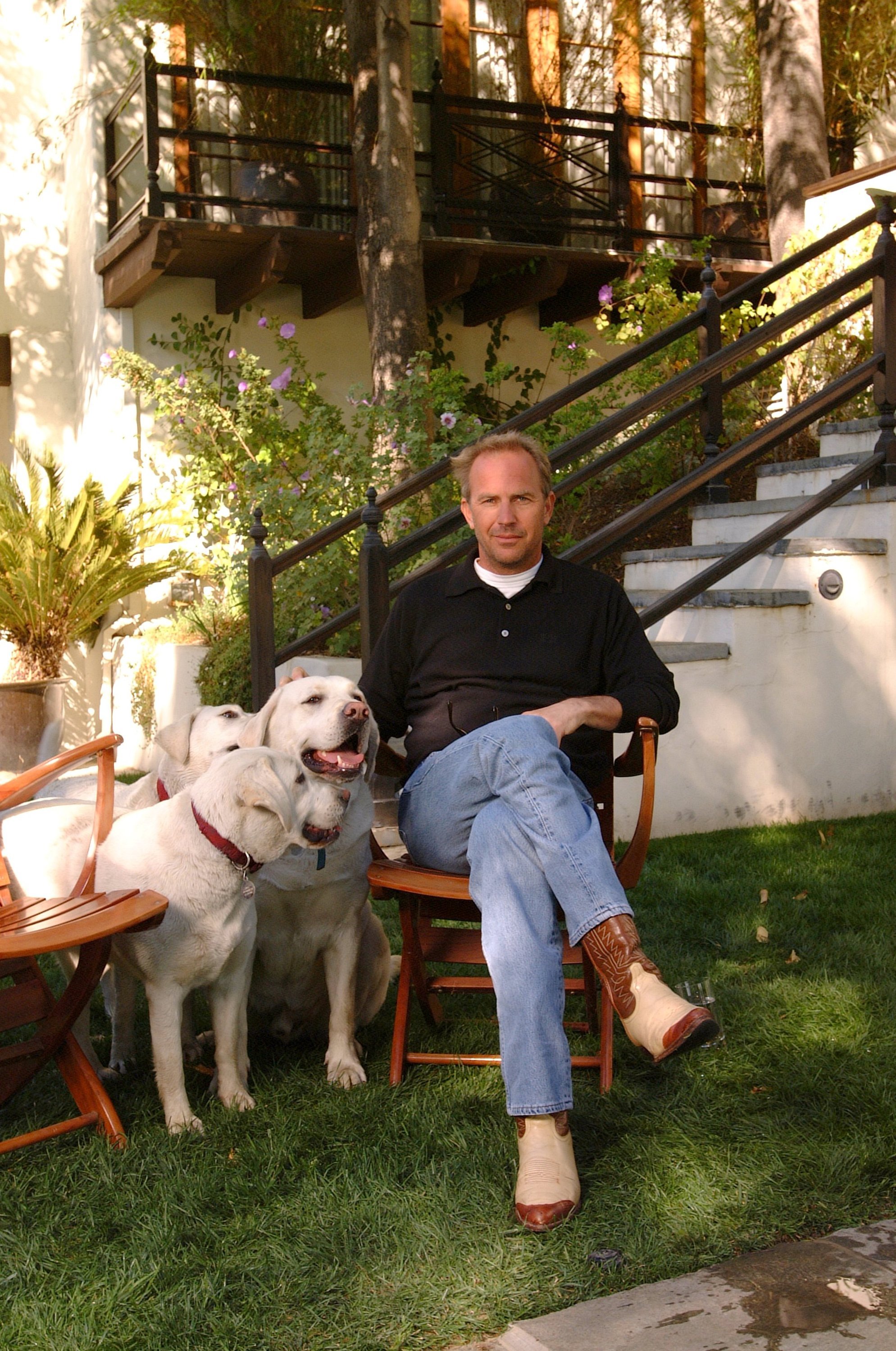 Kevin Costner with his dogs in the garden of his Spanish-style home on March 4, 2002, in the Hollywood Hills of California | Source: Getty Images