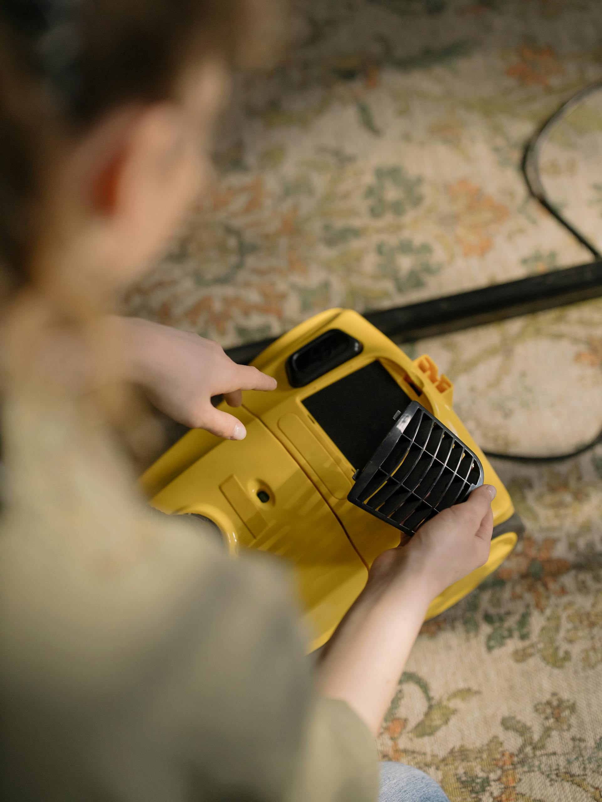 A woman holding a vacuum cleaner | Source: Pexels