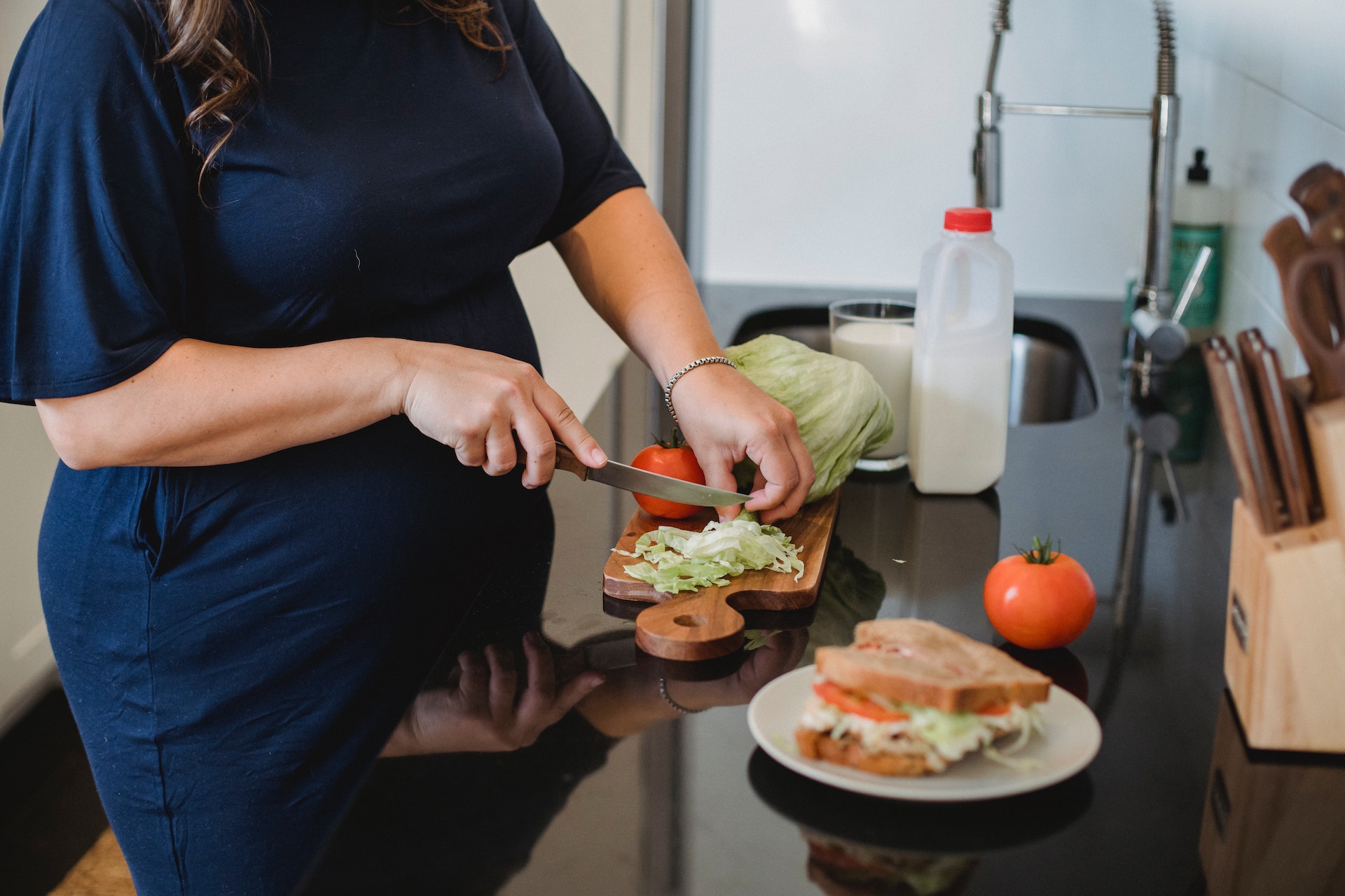 A pregnant woman cutting vegetables | Source: Pexels