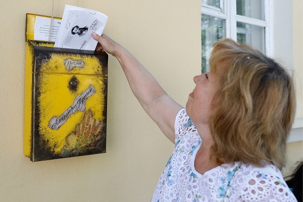 A woman puts a letter into a mailbox during the PushkinLeto festival marking the 220th birth anniversary of Russian poet Alexander Pushkin at the Alexander Pushkin Museum | Photo: Getty Images