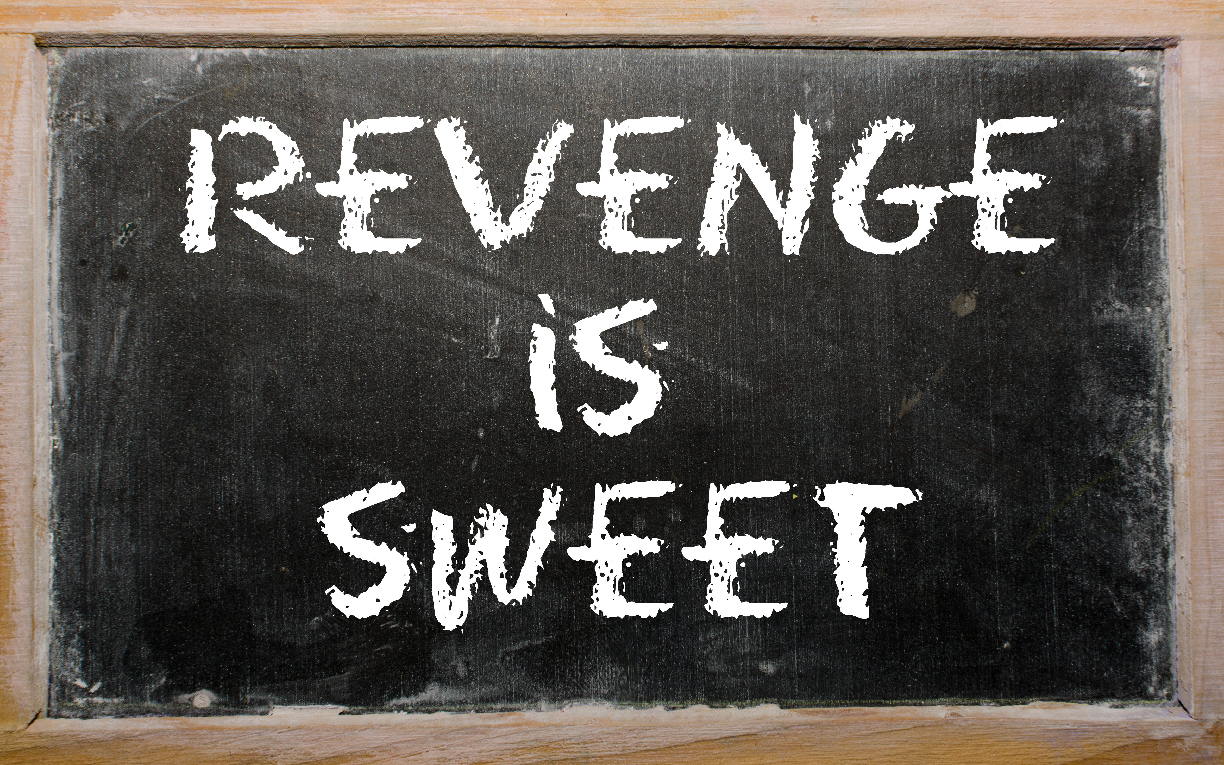 The words "Revenge Is Sweet" written on a chalk board | Source: Shutterstock