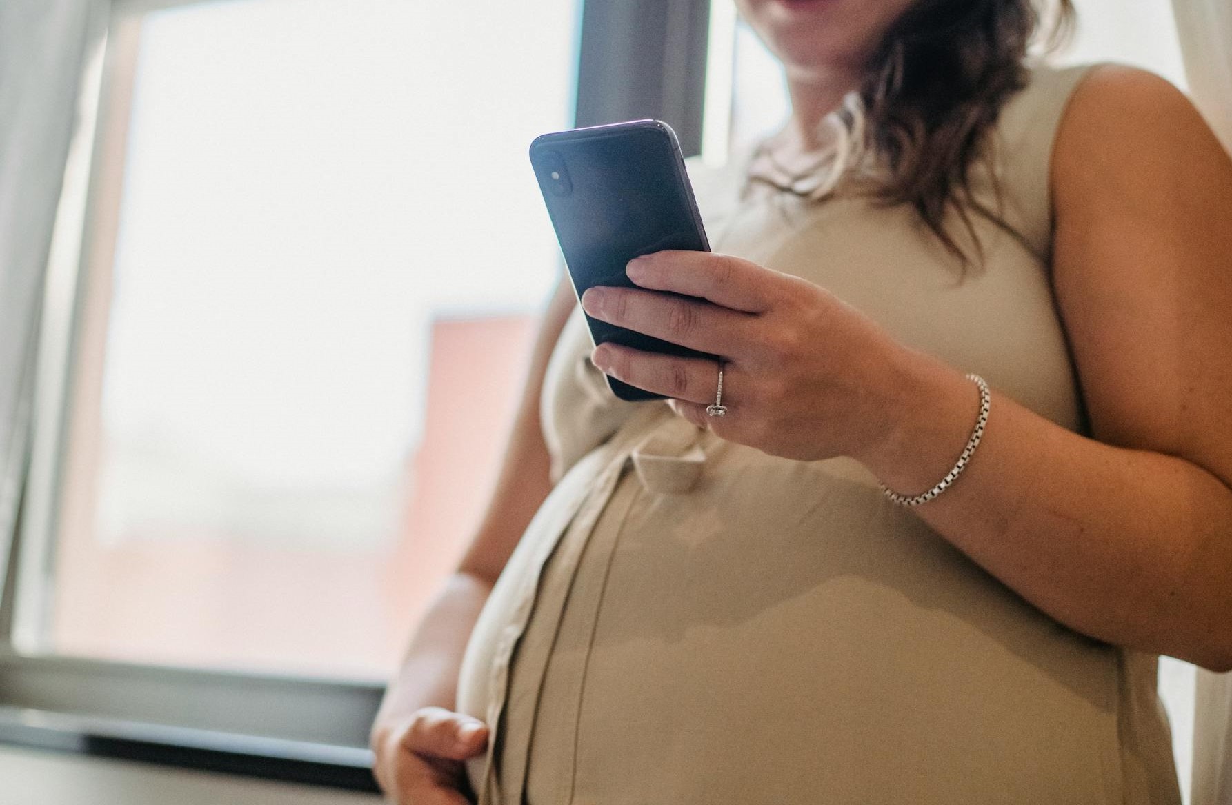 A pregnant woman holding a smartphone | Source: Pexels