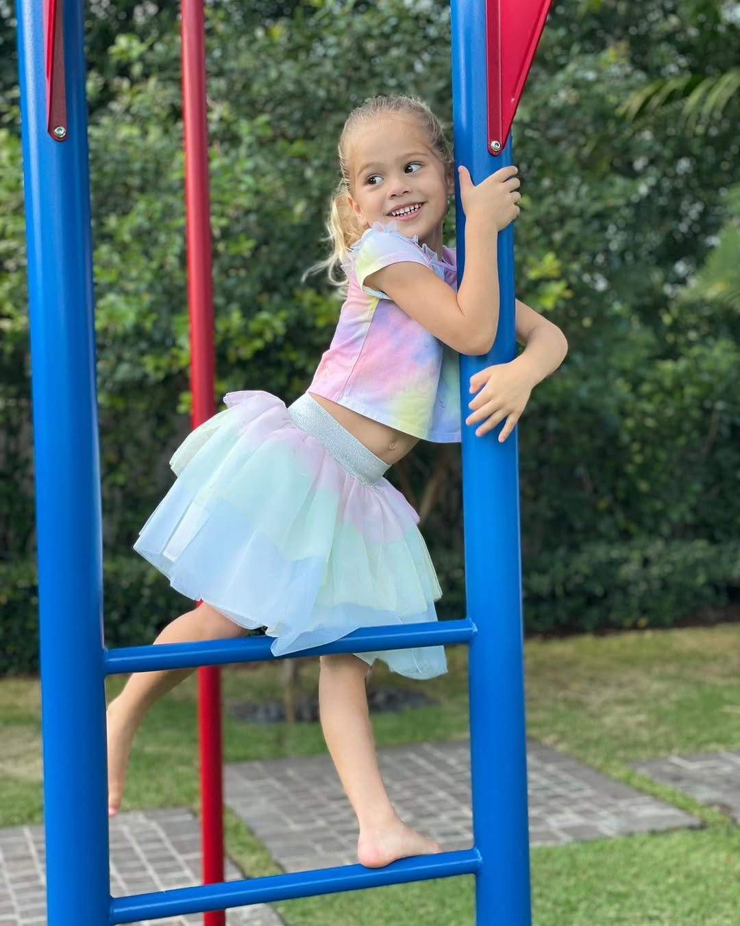 Lucy Iglesias wearing a colorful outfit on a playground, from a post celebrating her fourth birthday dated December 16, 2021 | Source: Instagram/annakournikova