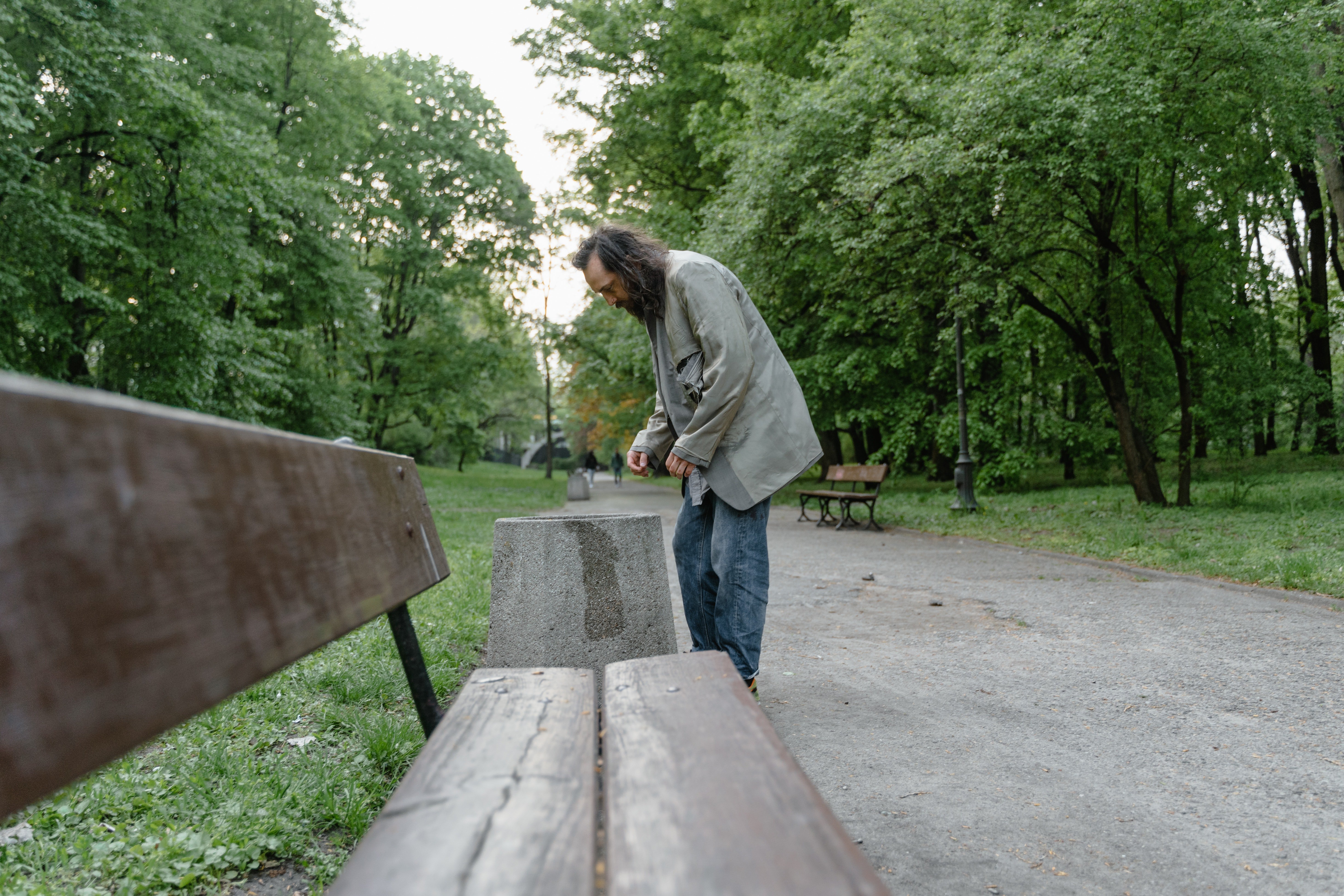 Un indigente cerca del banco de un parque. | Foto: Pexels