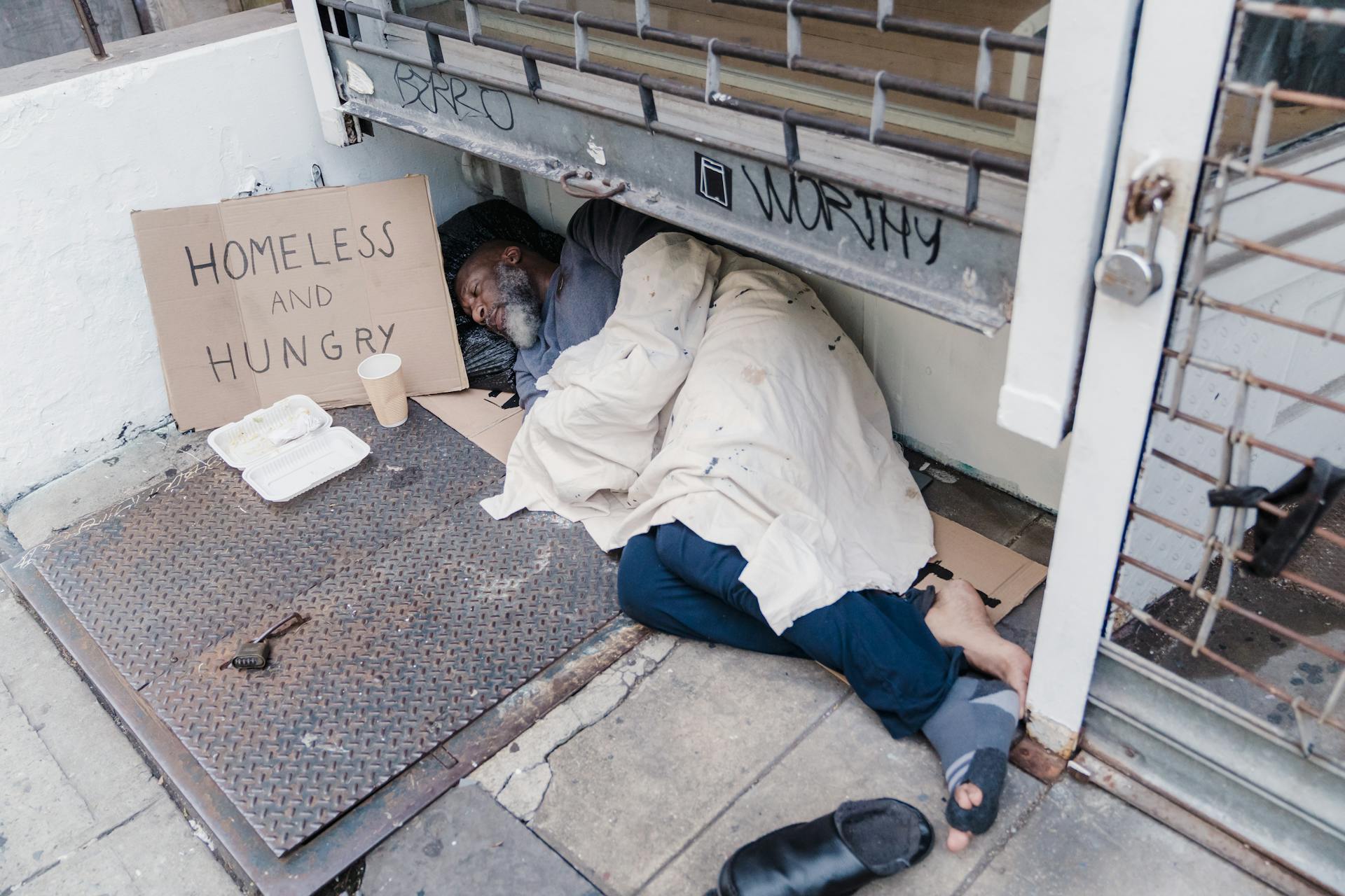 A homeless man lying on the street | Source: Pexels