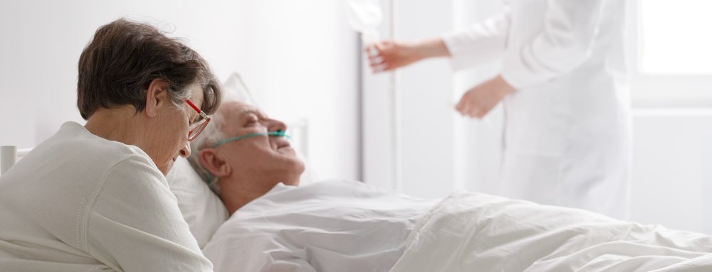Ältere Frau besucht einen sterbenden Mann im Krankenhaus. | Quelle: Shutterstock