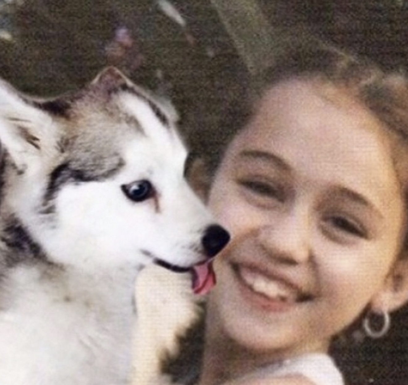 The songwriter posing with a dog, dated December 2014 | Source: Facebook/MileyCyrus