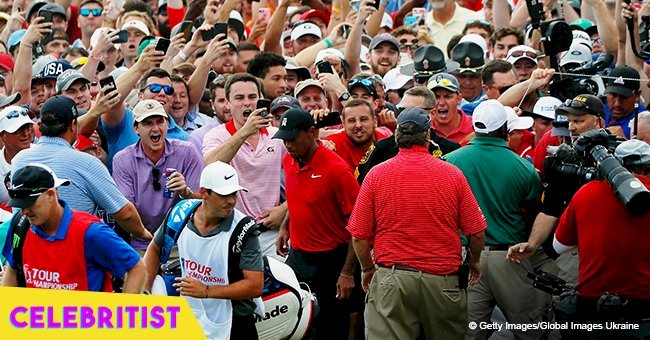 Tiger Woods disappears inside a sea of cheering fans after his first victory in five years