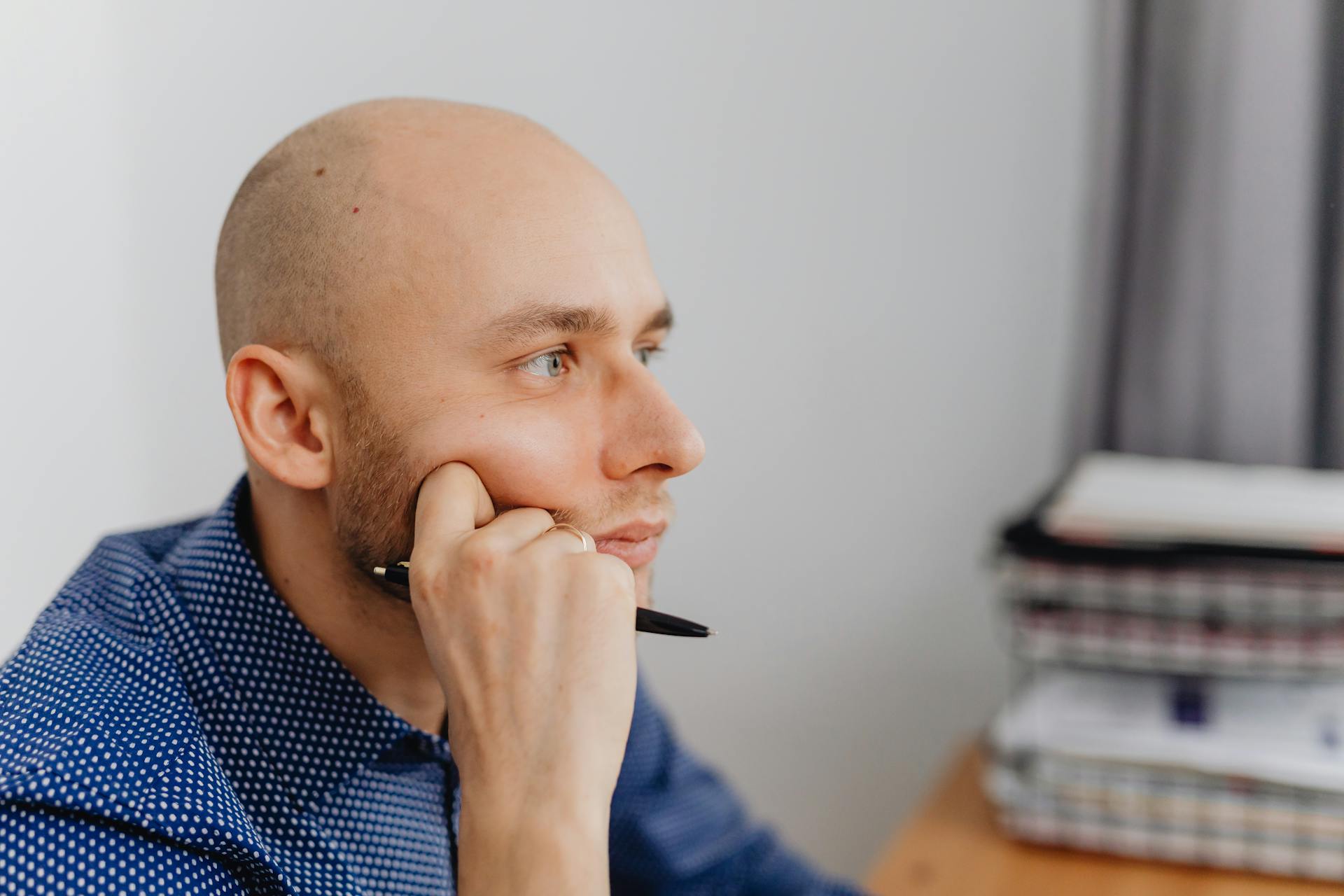 A man holding a pen and thinking | Source: Pexels