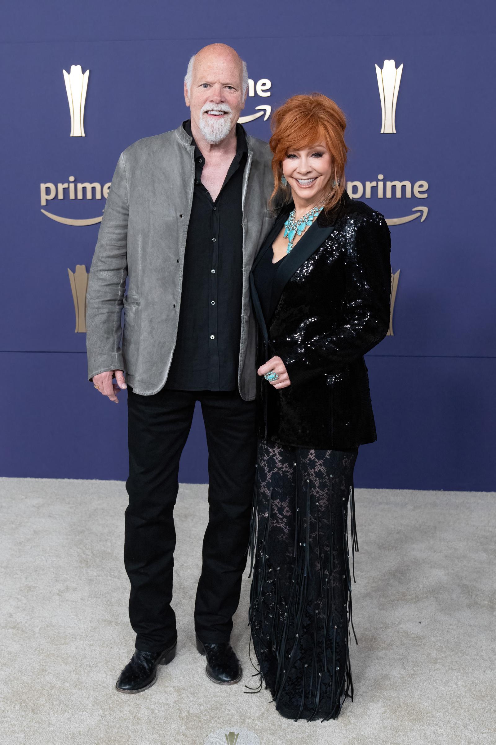 At the 59th Academy of Country Music Awards on May 16, they pose with Linn's arm around McEntire. Both smile at the camera.