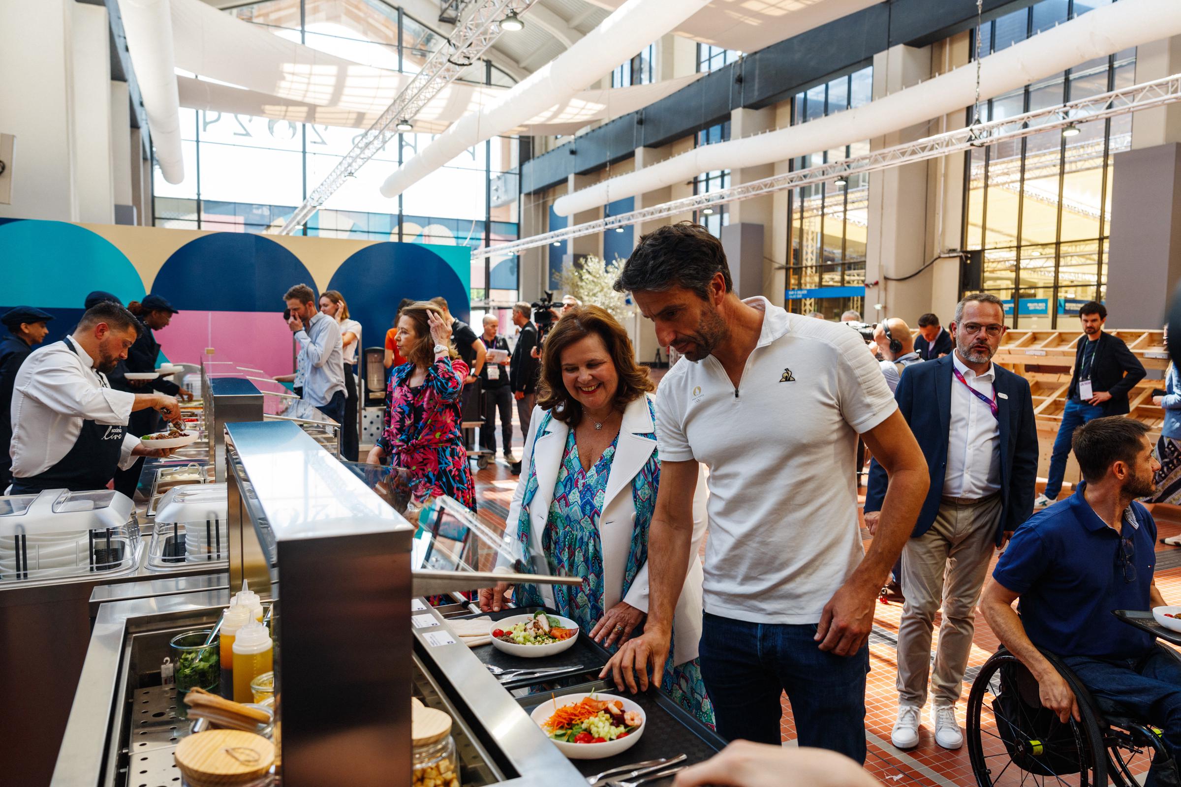 French President of the Paris 2024 Olympics and Paralympics Organising Committee (Cojo) Tony Estanguet (R) and Nathalie Bellon-Szabo, CEO of Sodexo Live! worldwide (L) at the Paris 2024 Olympic and Paralympic Village Restaurant in Saint-Denis on June 25, 2024 | Source: Getty Images